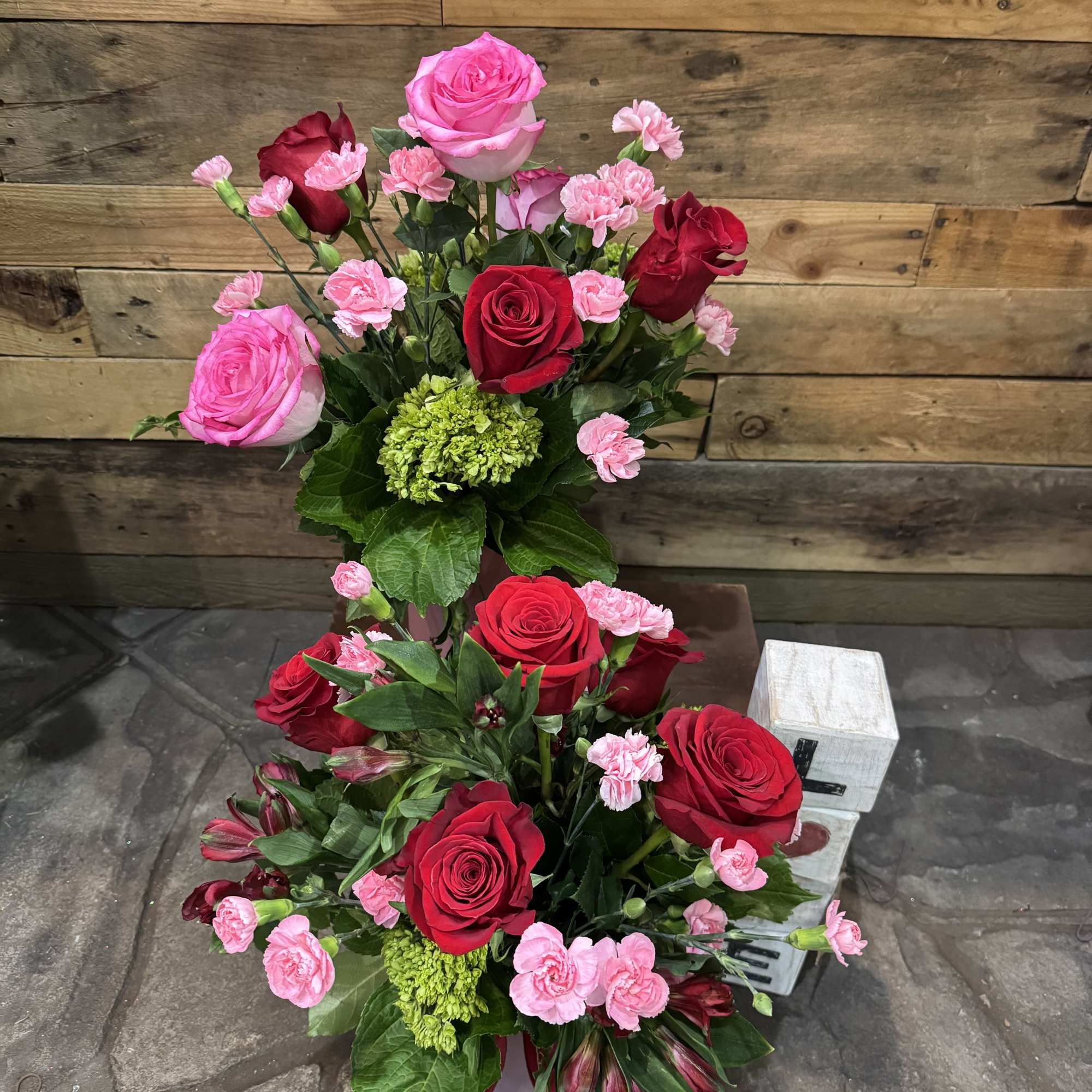 Pretty light pink vase with beautiful Ecuadorian red roses and mini carnations.