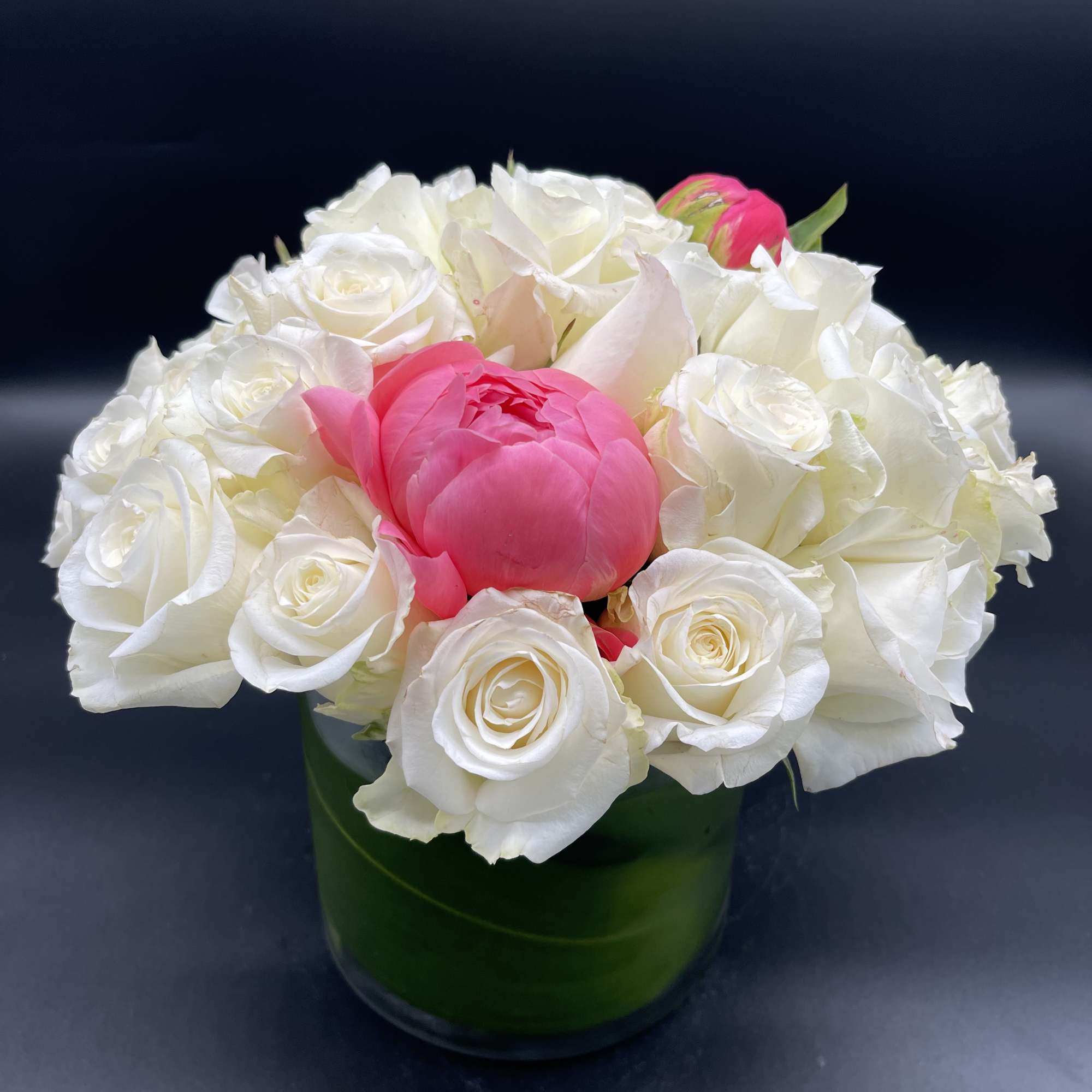 Three  stunning peonies surrounded by white roses. 