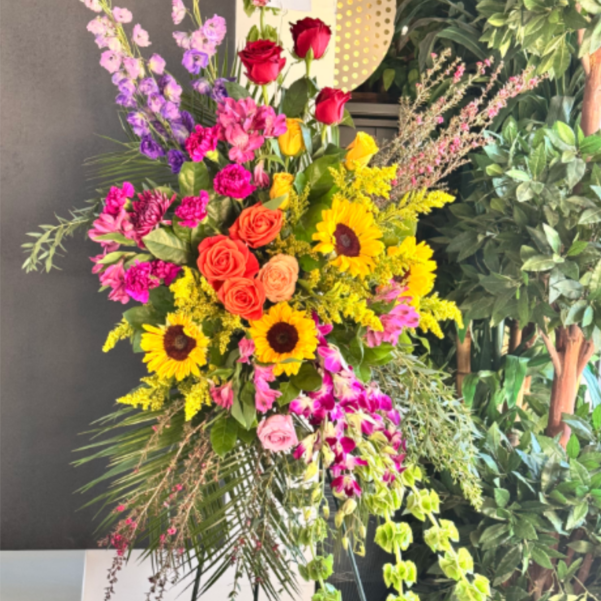 A vivid, tall standing sympathy spray that reads more like a celebratory