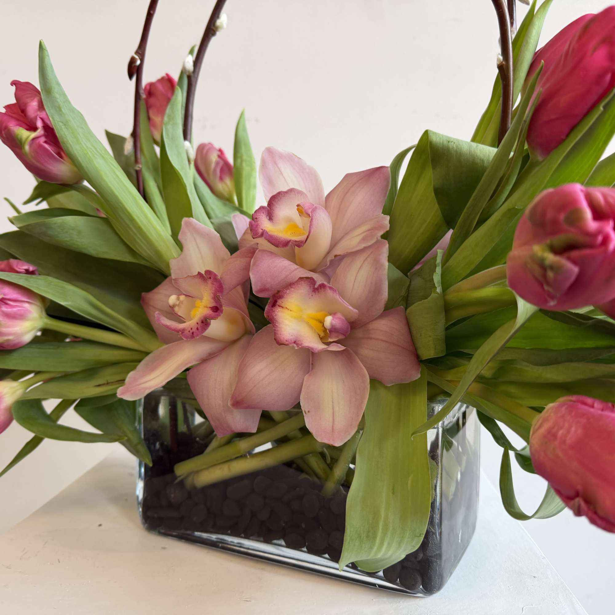 Marvel Parrot tulips
cymbidium orchid pink,
black stones 
in short vase 