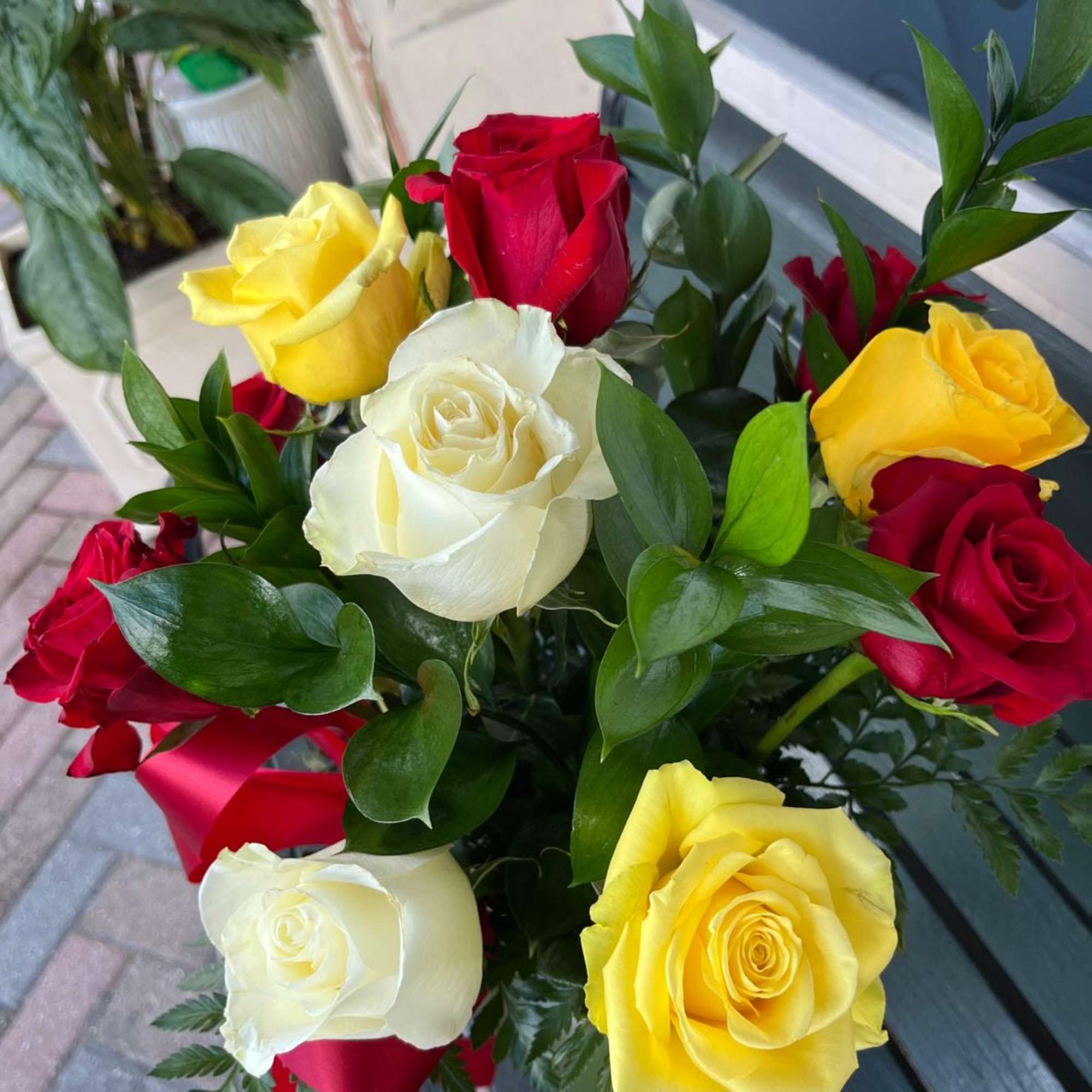 Bouquet of red, yellow, and white roses with greenery