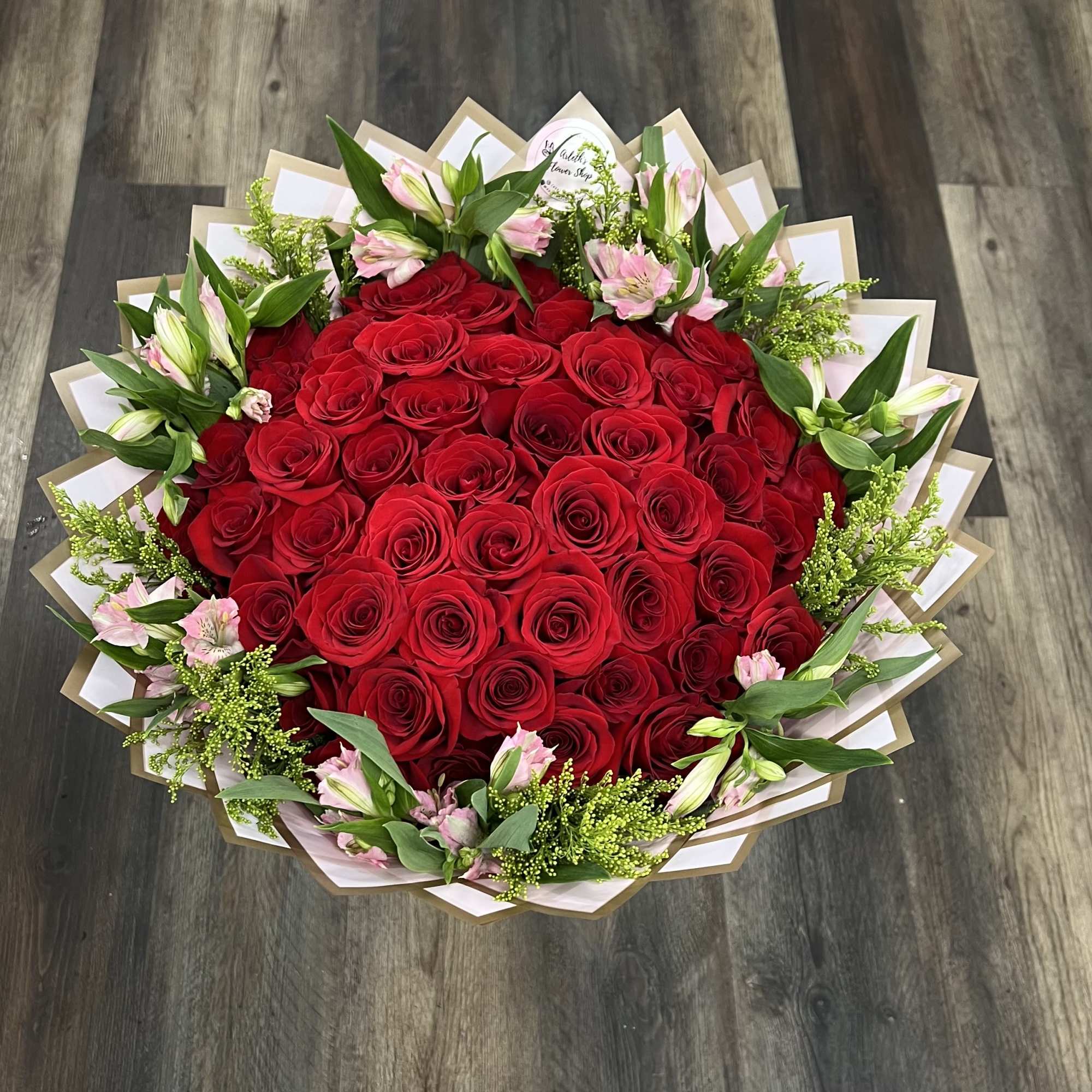 Large bouquet of red roses with pink lilies and greenery