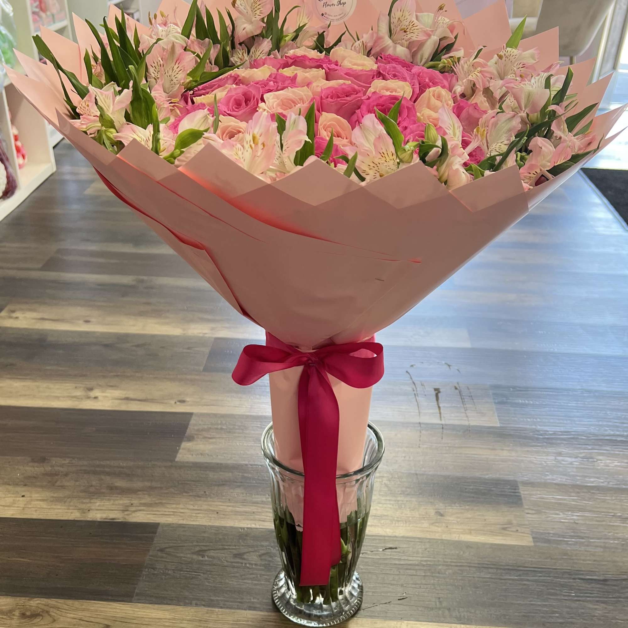 Pink rose bouquet with pale alstroemeria in a clear glass vase