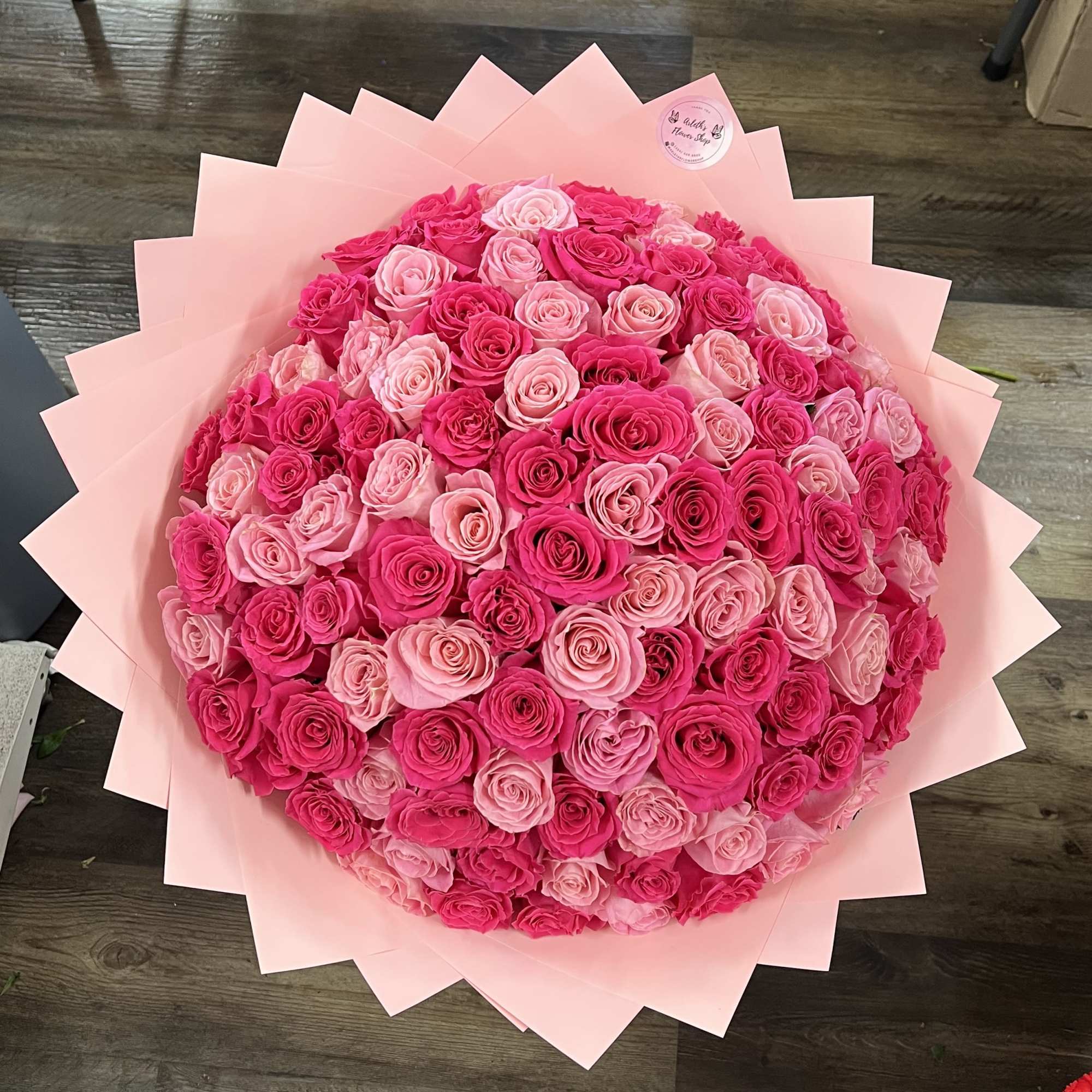 Large bouquet of pink and hot pink roses wrapped in pale pink paper