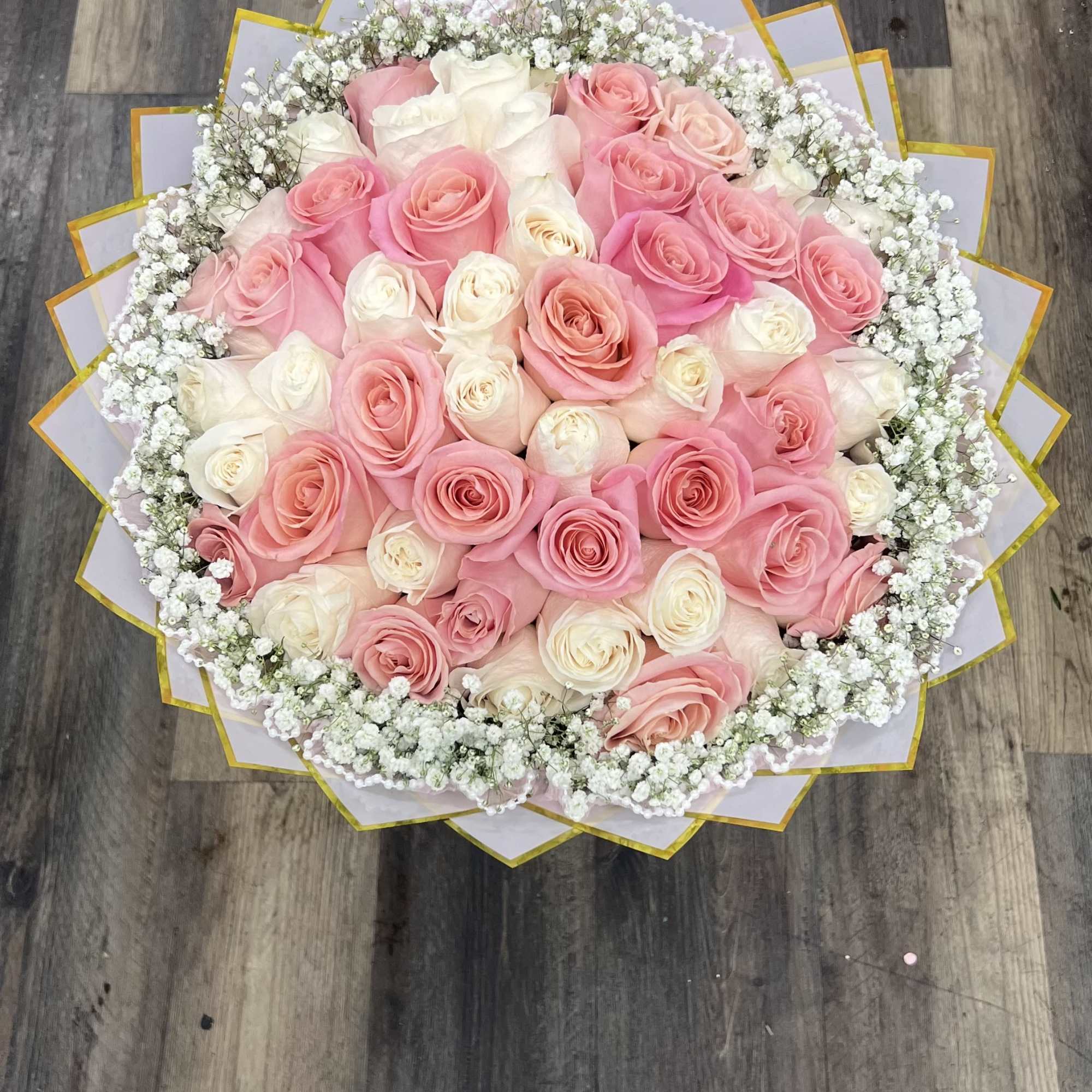 Round bouquet of pink and white roses with baby's breath