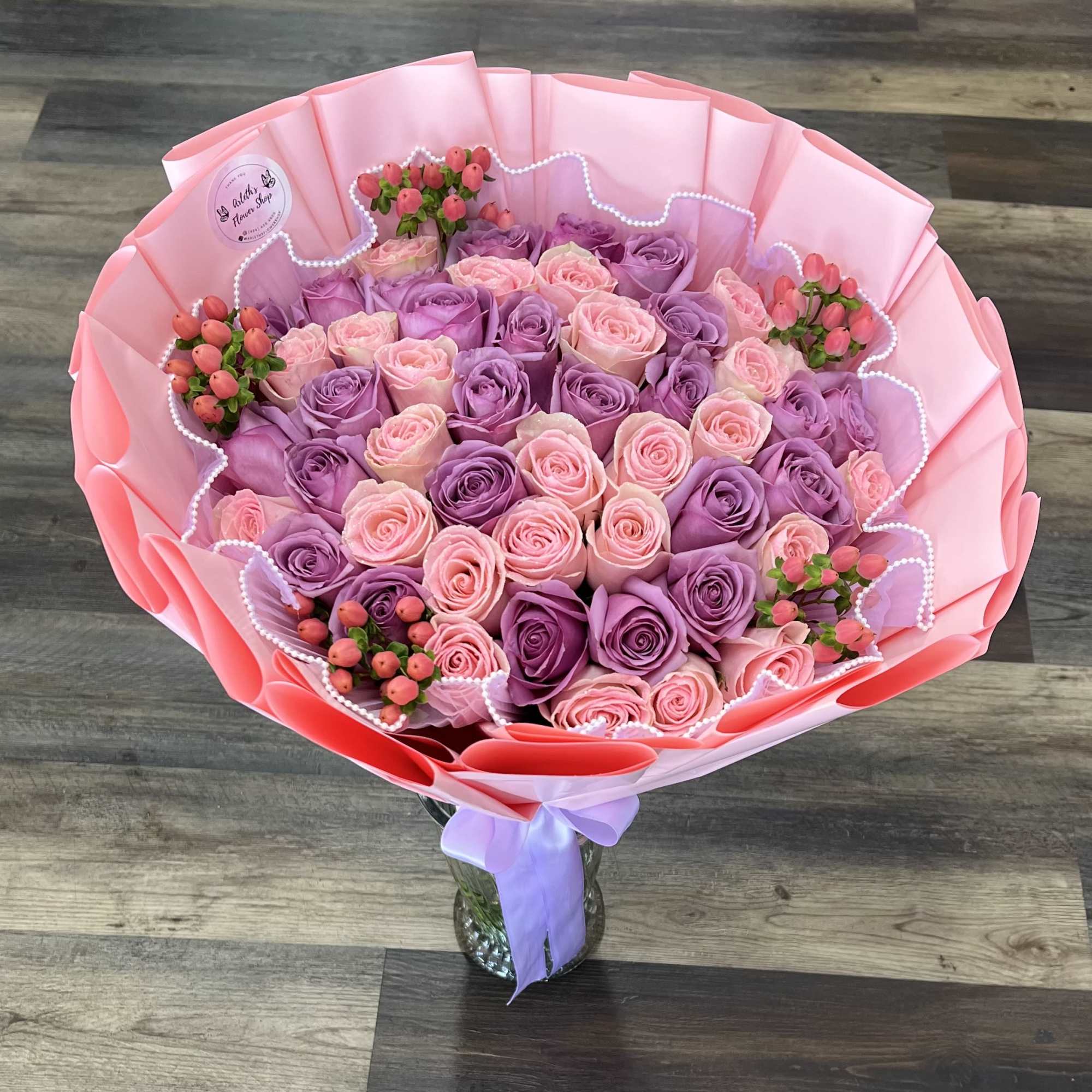 Bouquet of pink and lavender roses wrapped in pink paper