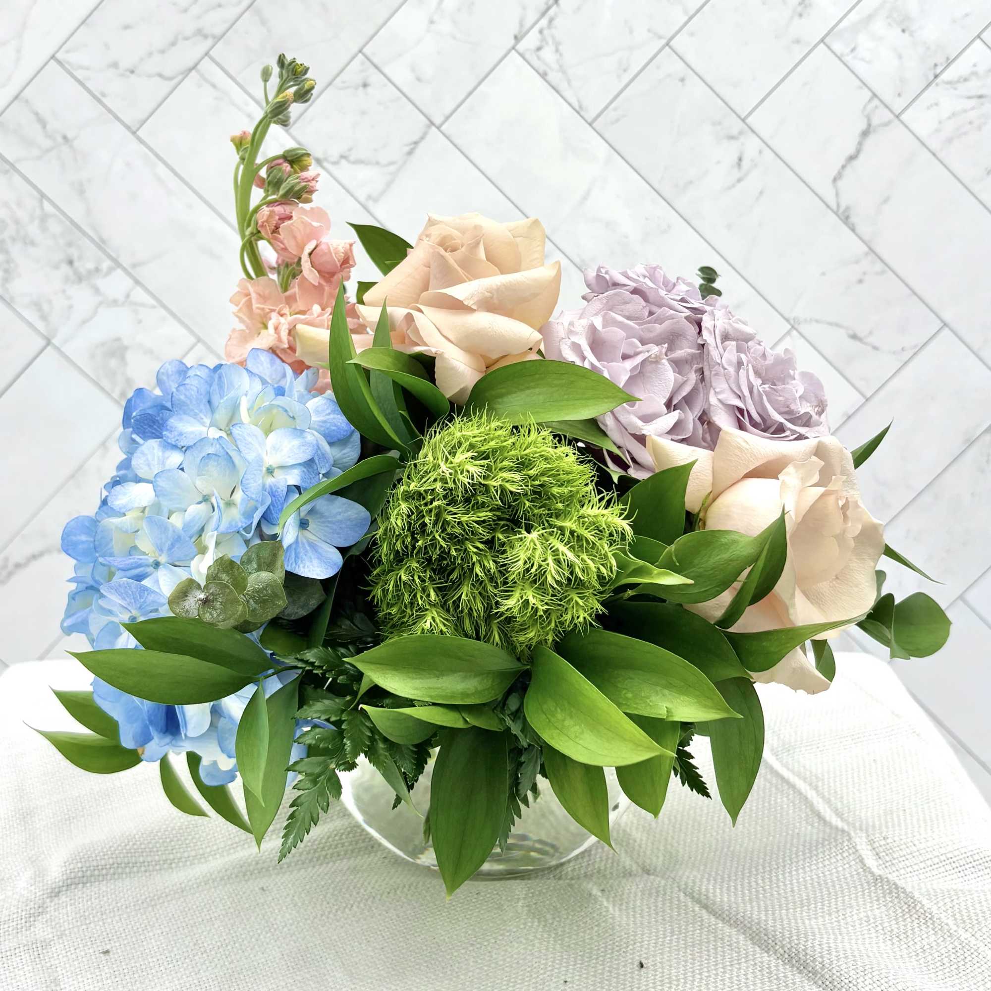 Quicksand roses, blue hydrangeas &amp; green dianthus in a summery low arrangement-vibrant