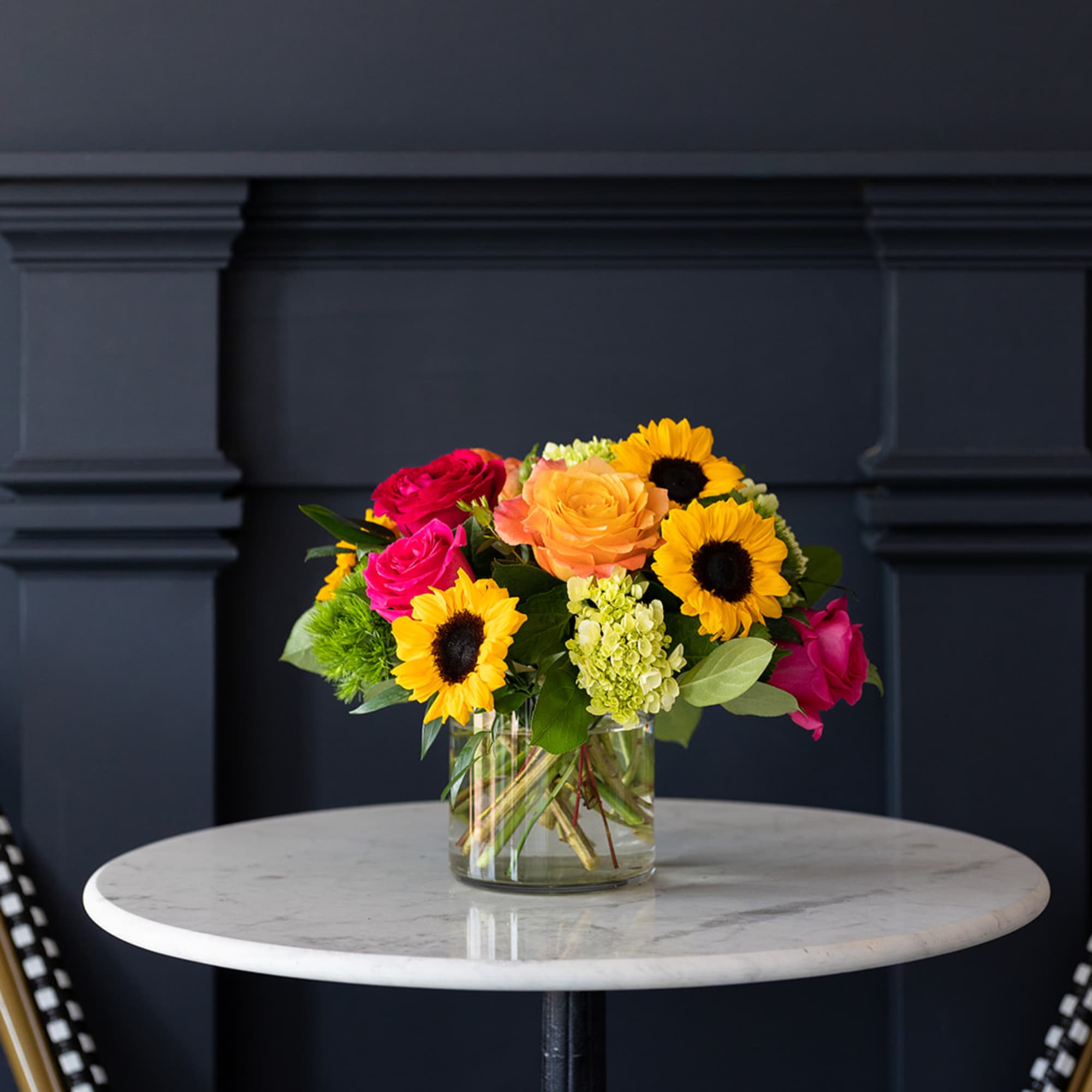 Bouquet of sunflowers and roses in a clear glass vase