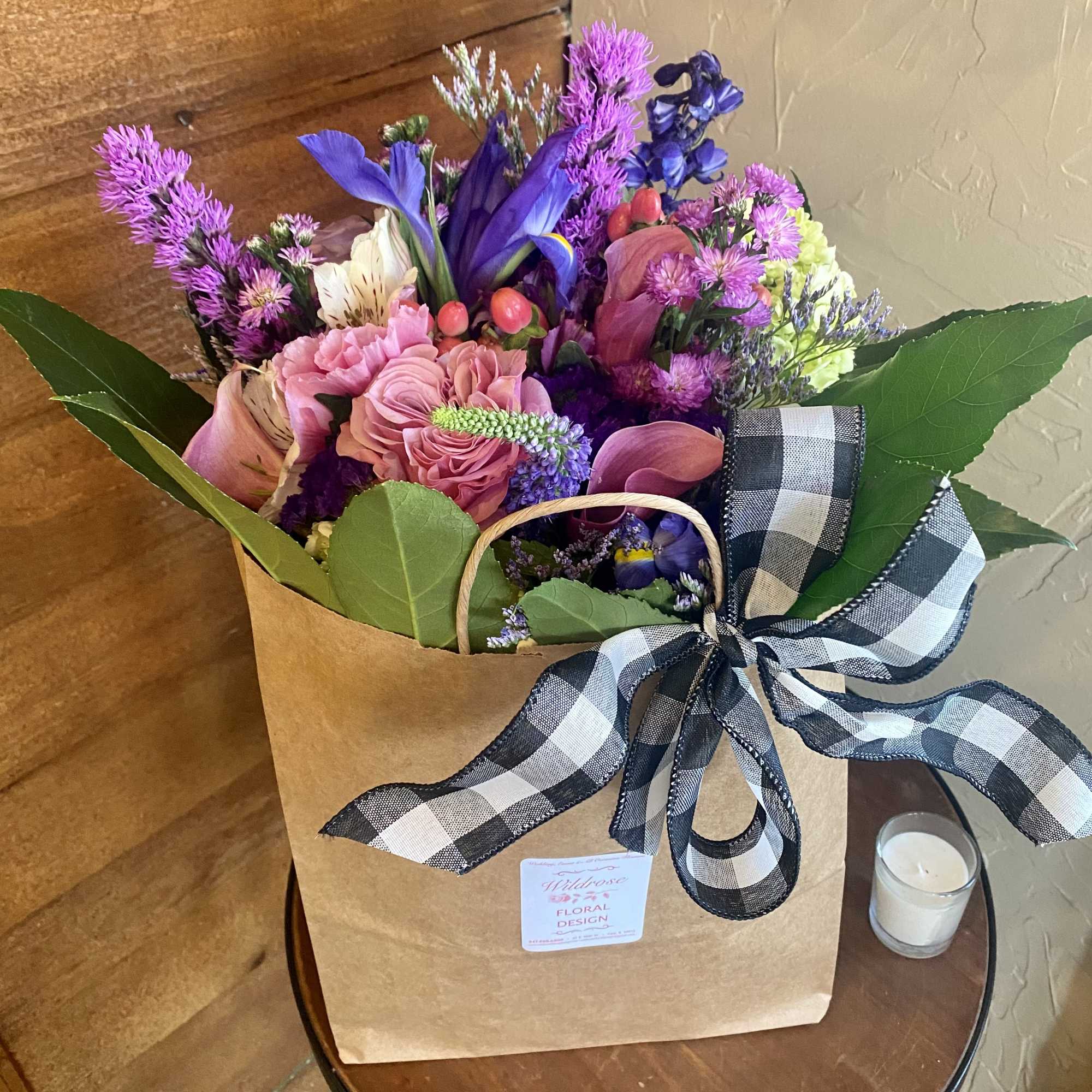 Mixed bouquet in a kraft paper bag with a black-and-white ribbon