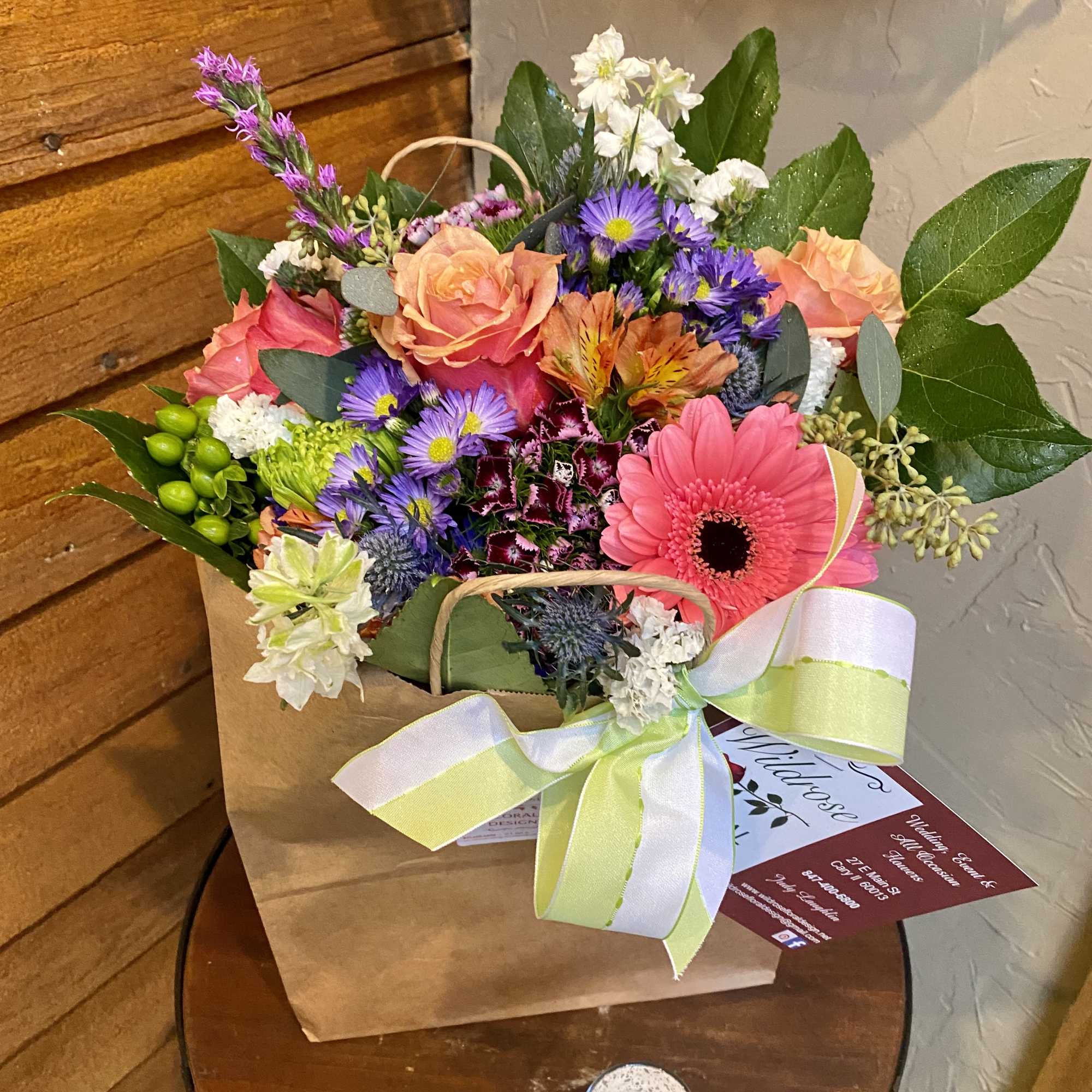 Mixed bouquet in a paper bag with a ribbon bow