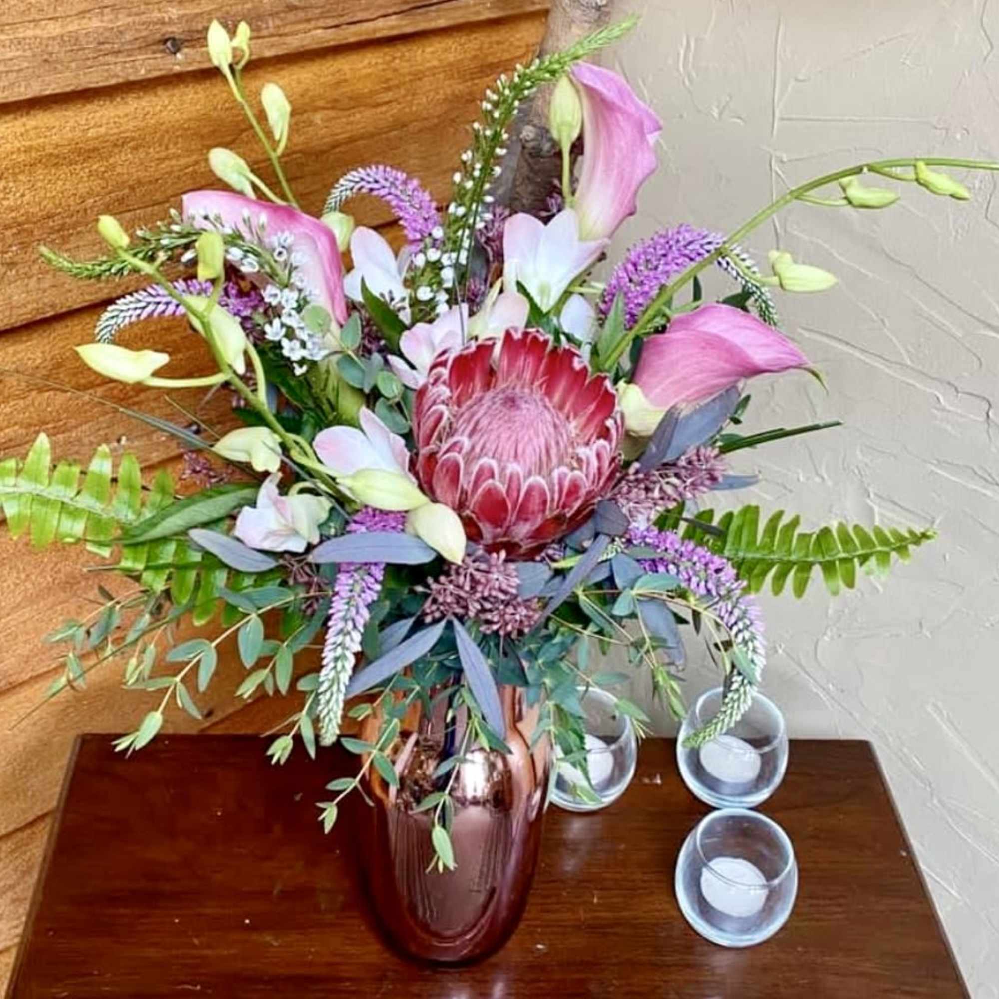Pink and purple floral arrangement in a glass vase on a table