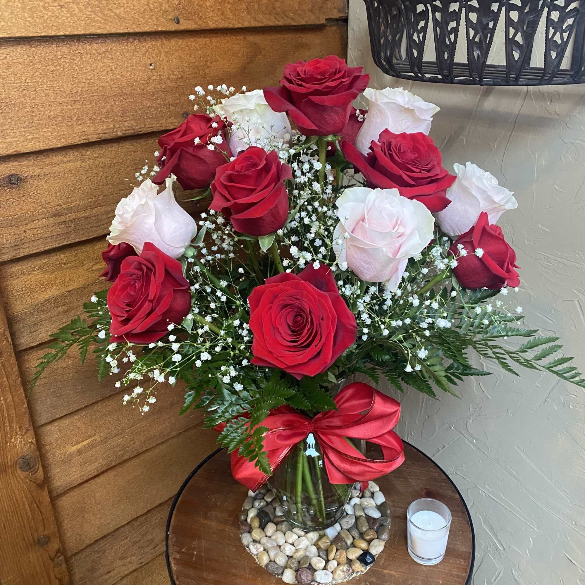 Bouquet of red and white roses in a glass vase with a red ribbon