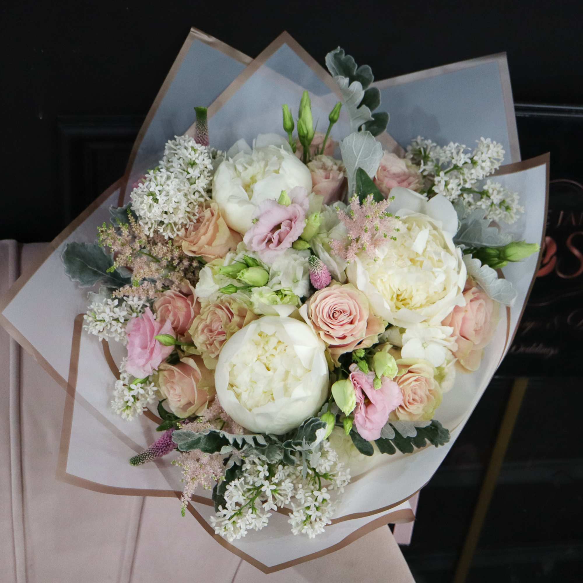 Bouquet of white and blush flowers wrapped in white paper