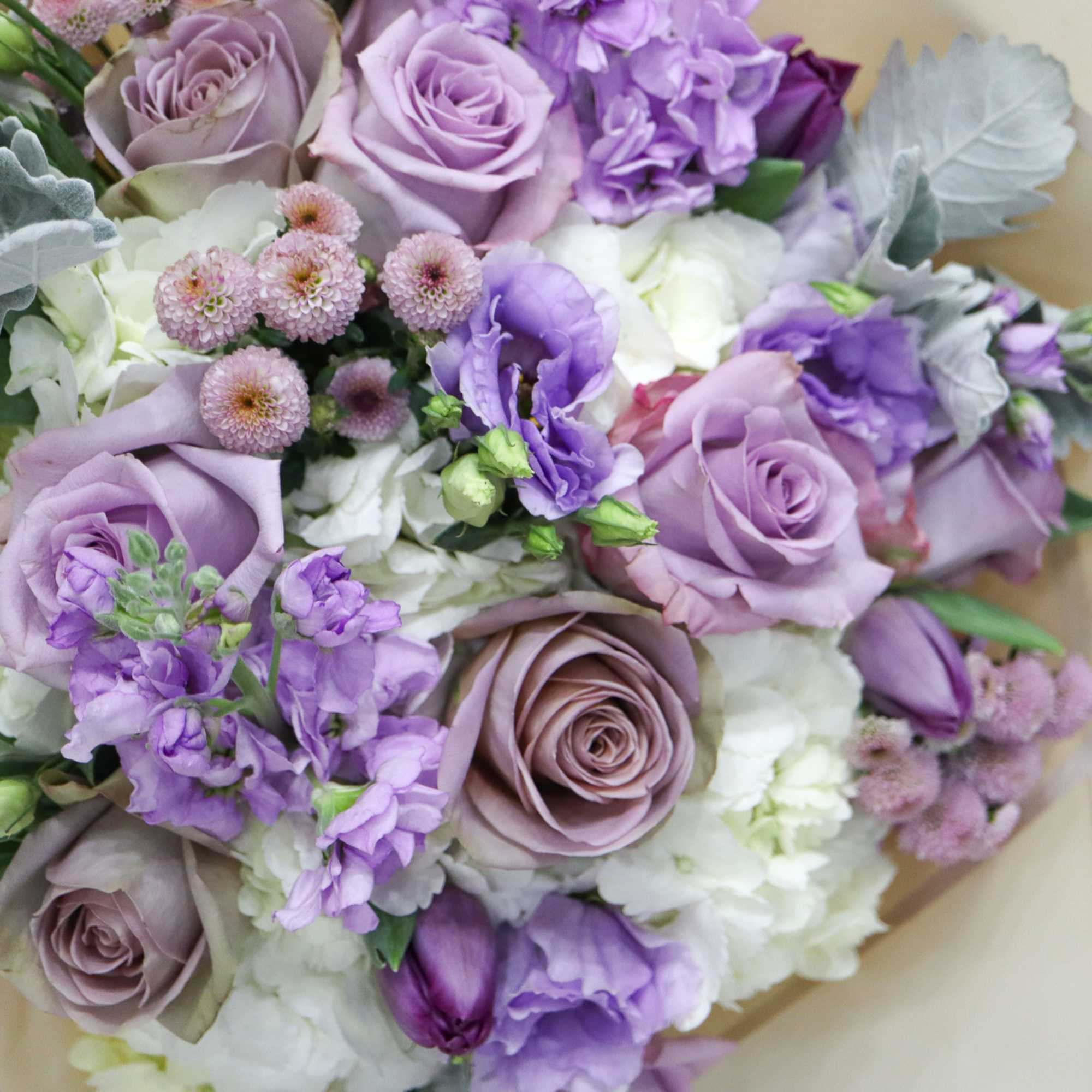 Lavender and white bouquet with roses and small purple blooms