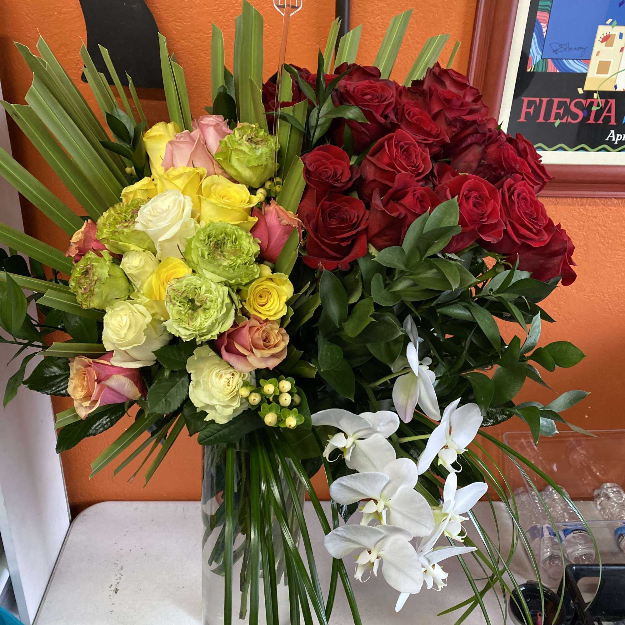 A striking tall bouquet that pairs classic roses with cascading phalaenopsis orchids