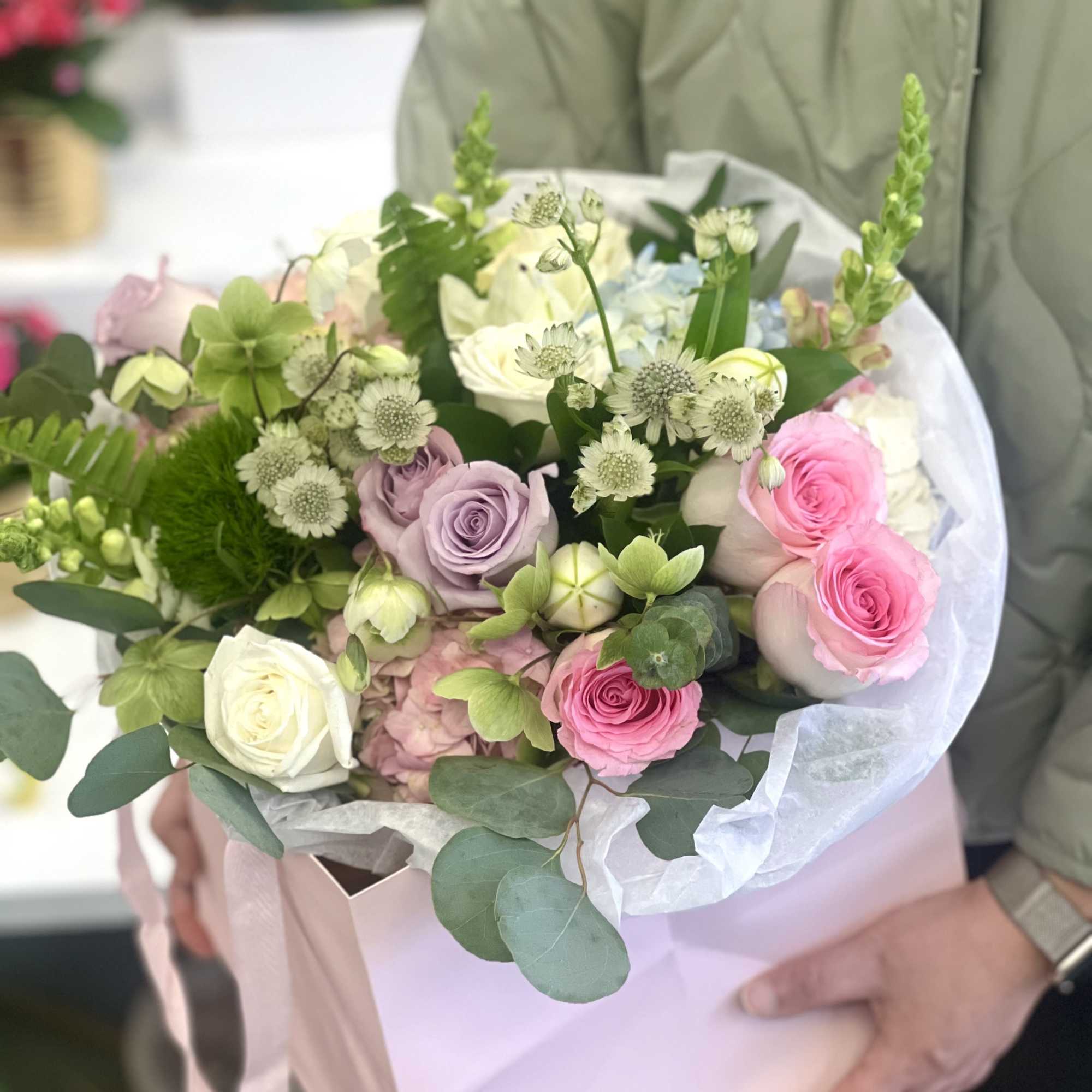 A soft and romantic arrangement featuring blush pink, ivory, and lavender roses