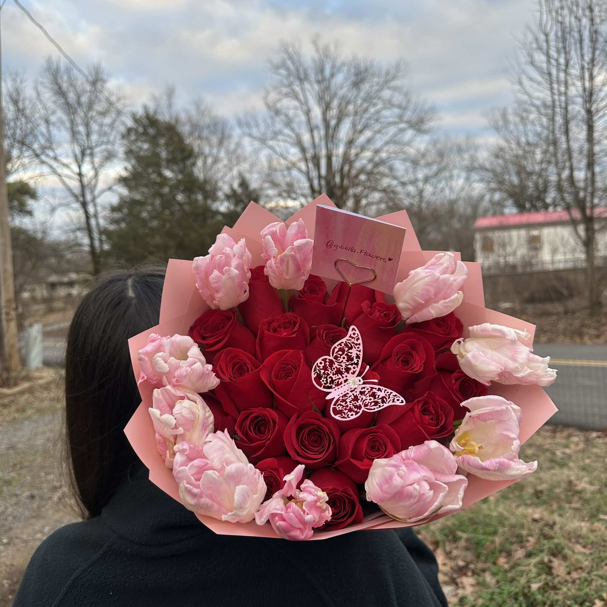 Bouquet of red roses and pink tulips in pink wrap