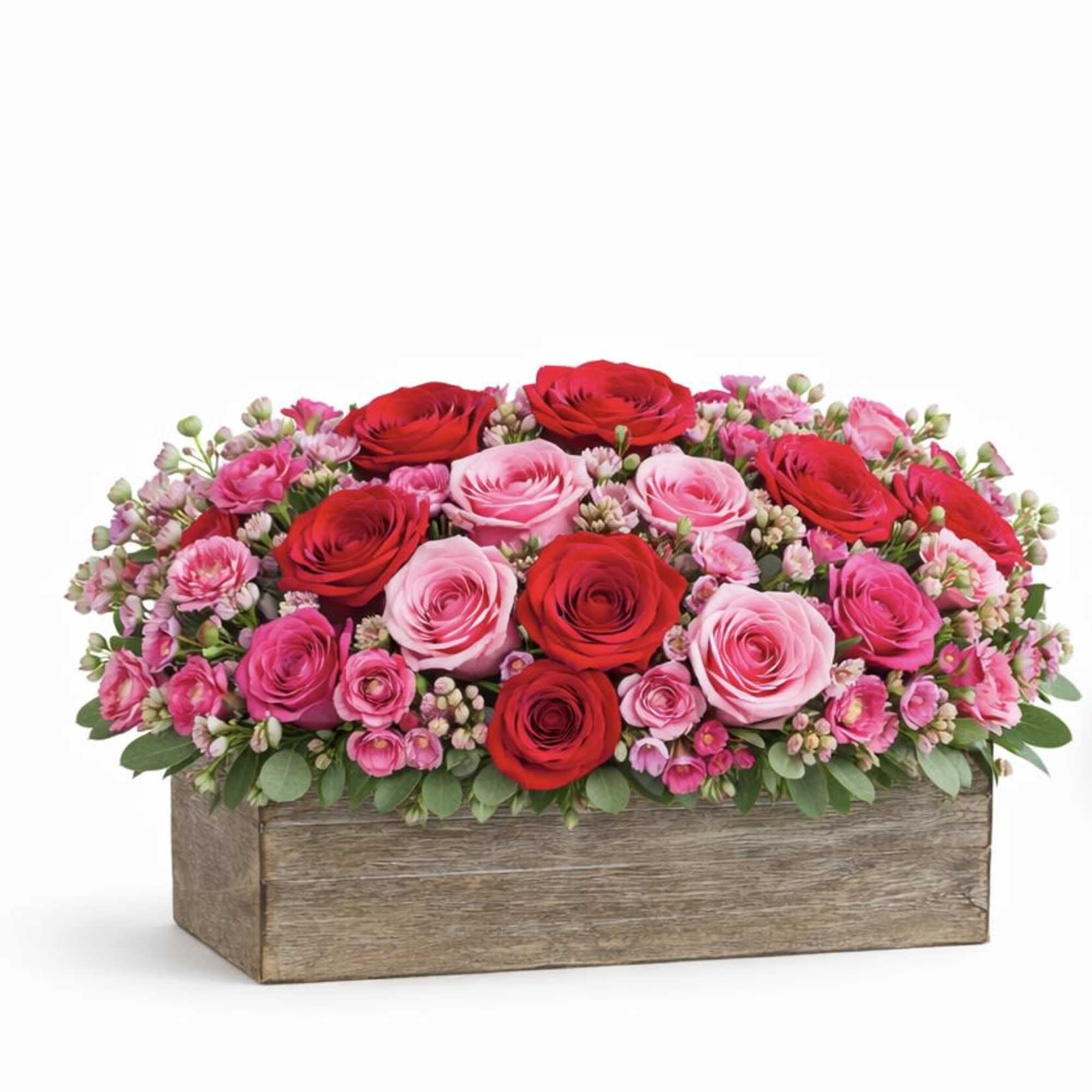 Pink and red roses arranged in a wooden box