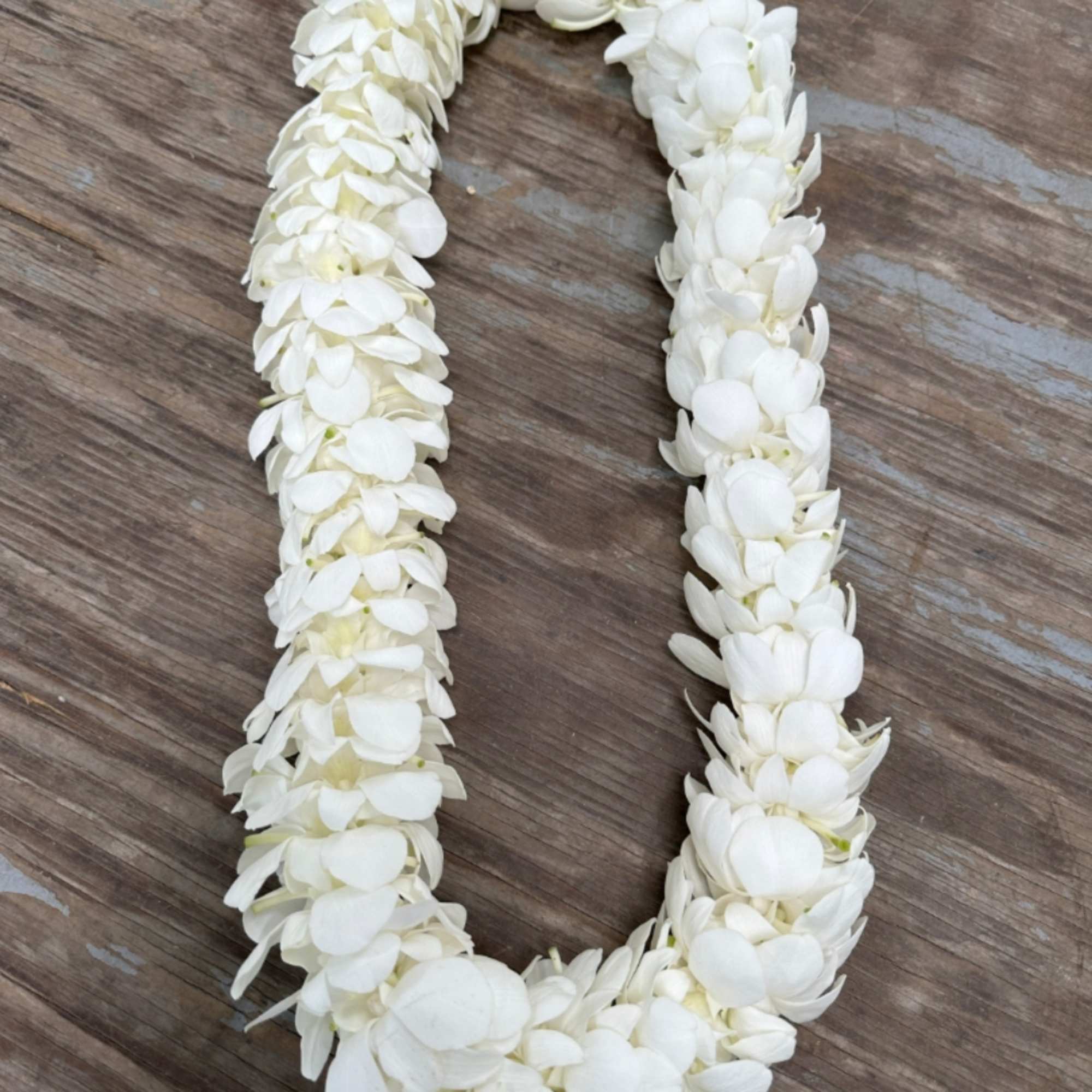 White flower lei on a wooden surface