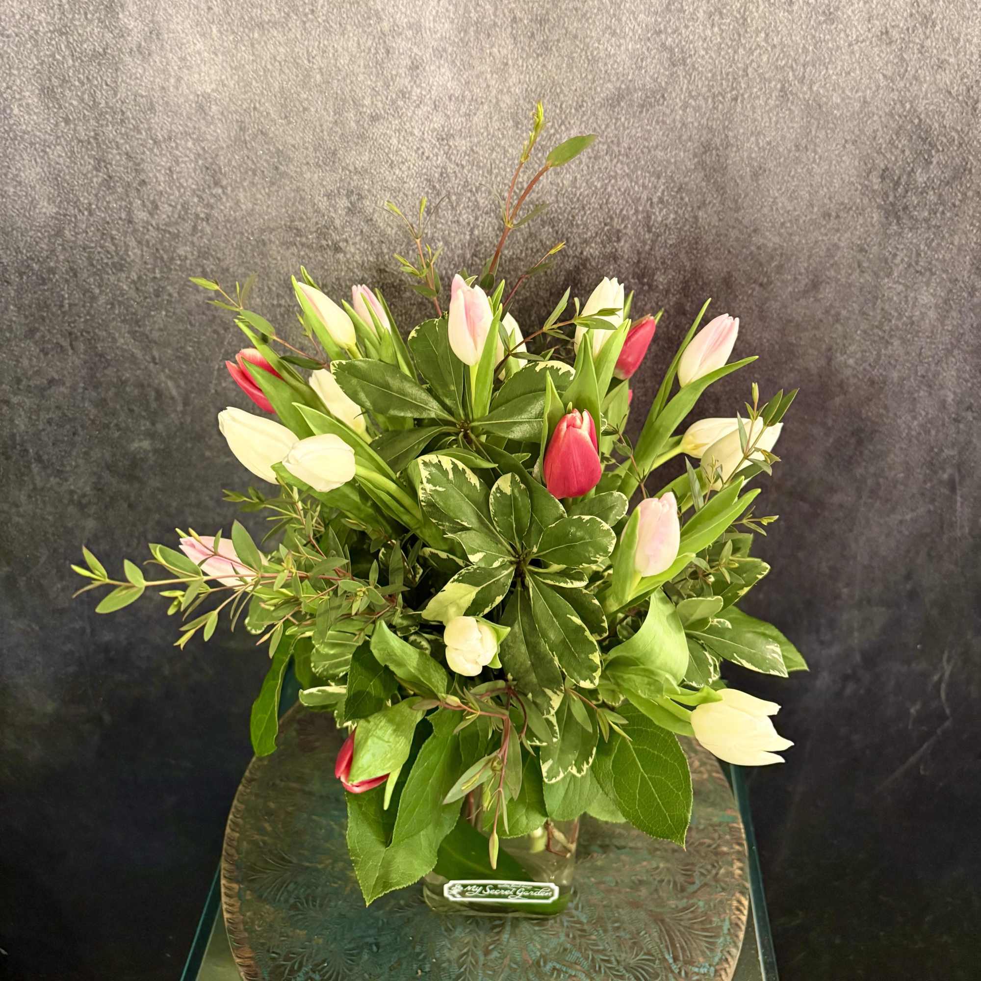 Bouquet of pink and white tulips in a glass vase