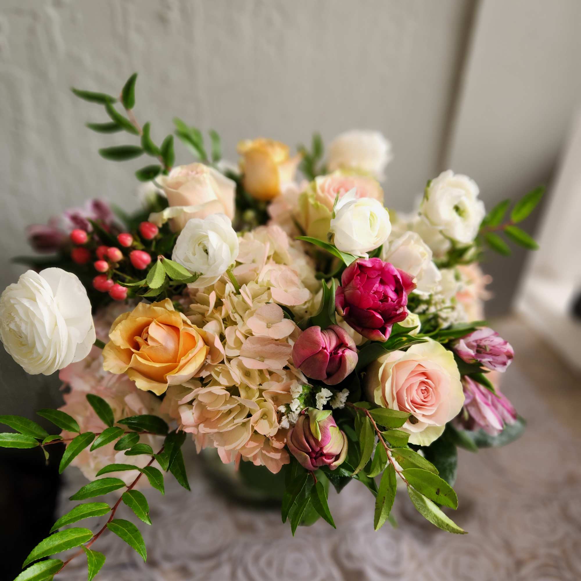 Mixed bouquet of roses, ranunculus, and hydrangea in soft pink and cream