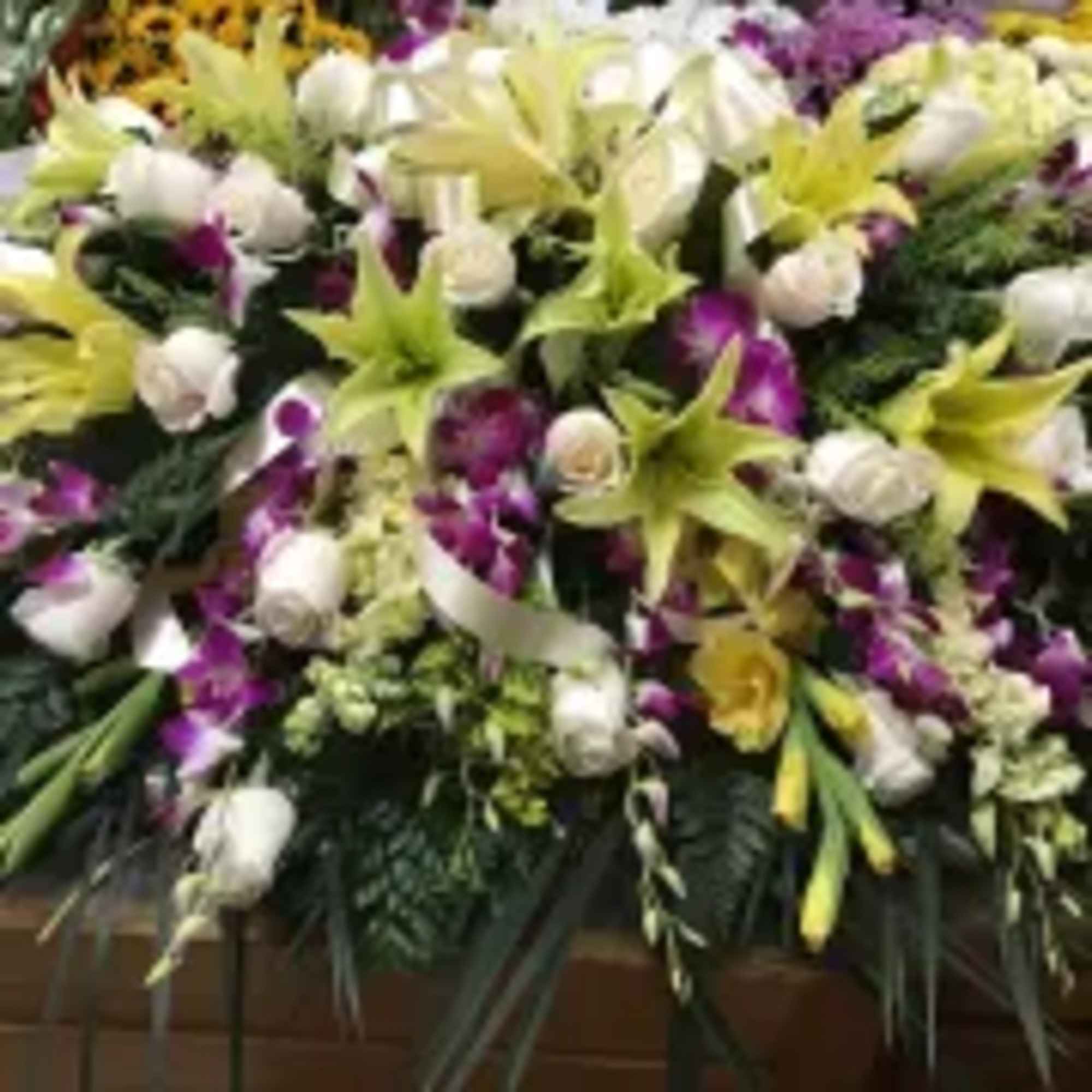 This casket spray make with purple dendrobium orchids and yellow wind lily