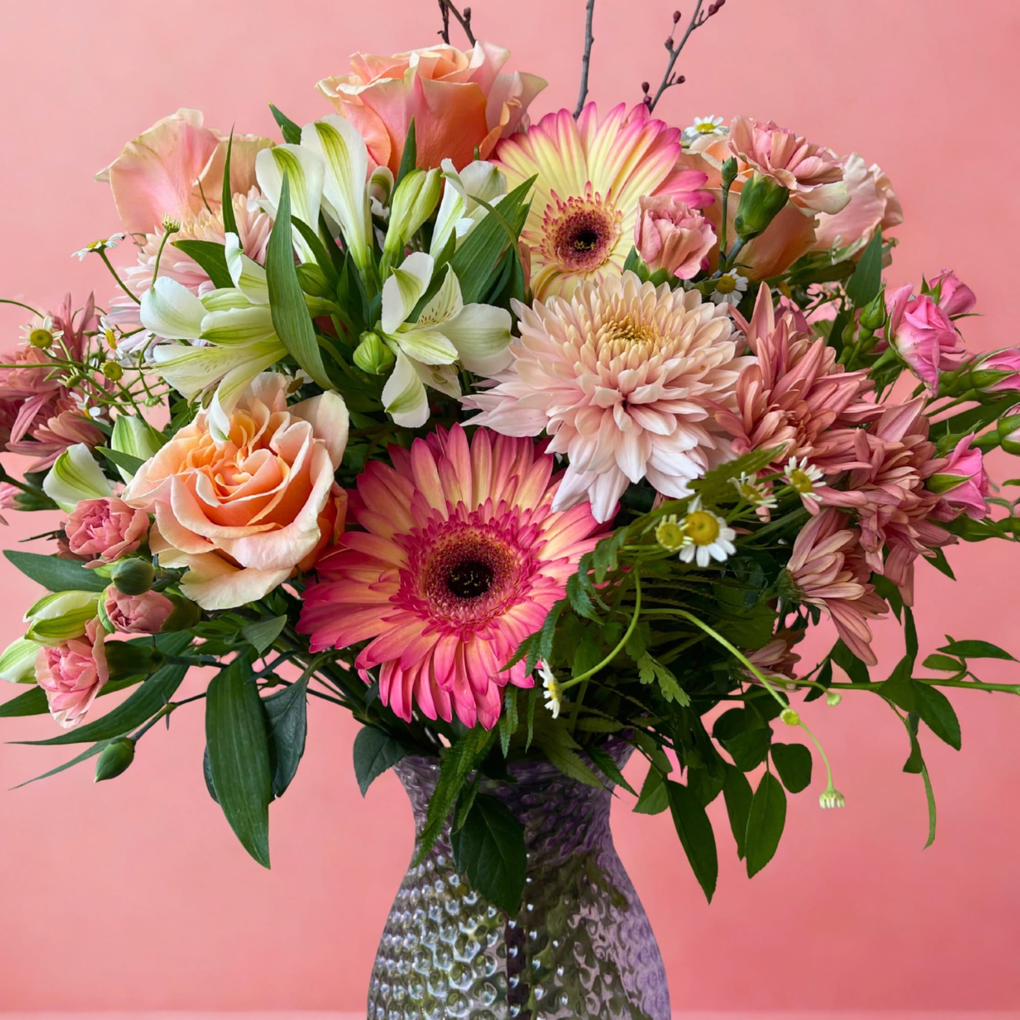 Mixed pink and peach bouquet in a textured glass vase