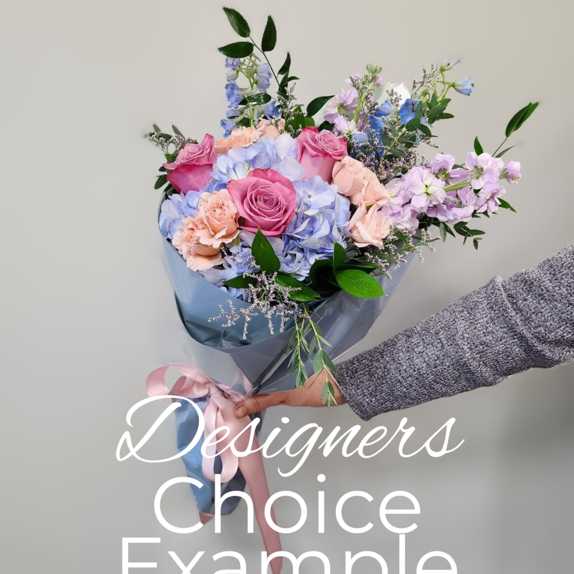 Hand-tied bouquet of pink roses, blue hydrangeas, and peach carnations