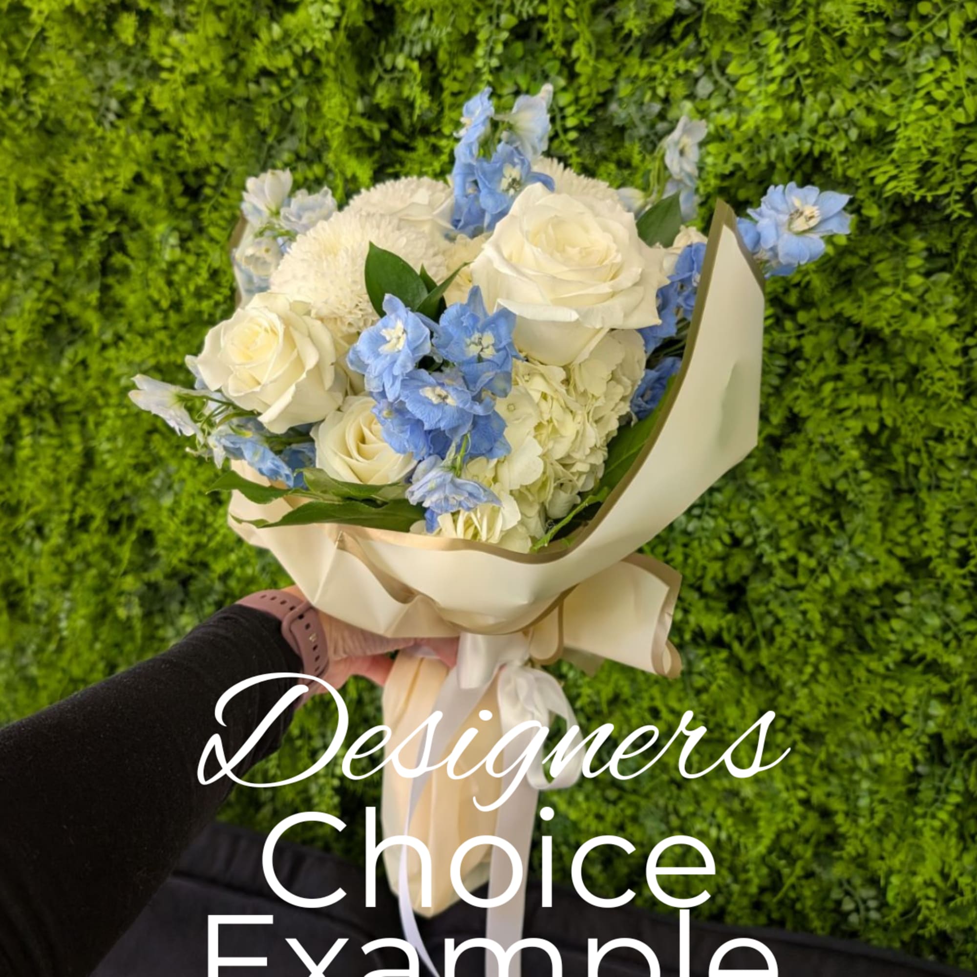 Bouquet of white roses and blue flowers wrapped in cream paper