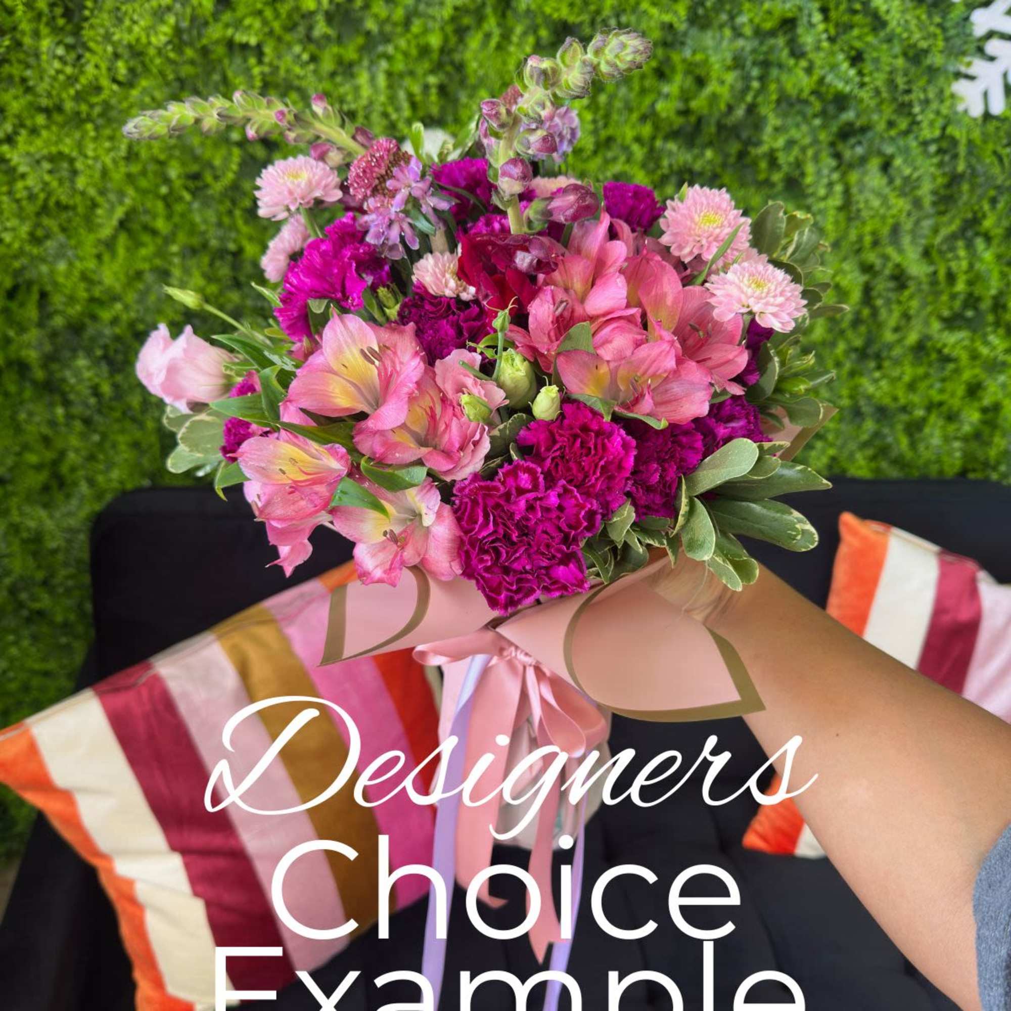 Handheld bouquet of pink and magenta flowers with a ribbon wrap