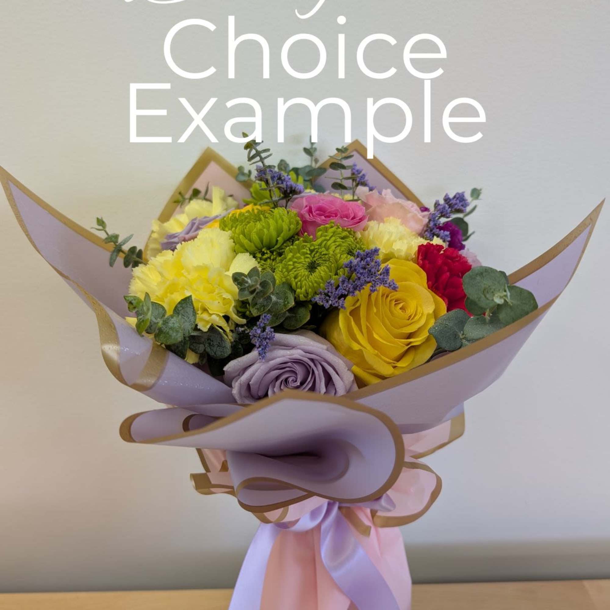 Mixed bouquet of roses, carnations, and chrysanthemums wrapped in lavender paper