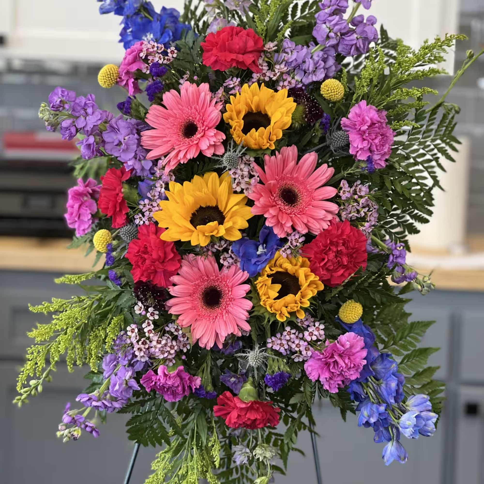 Mixed garden stylar arrangement. Features snap dragons, lily's, roses, stock, button mums