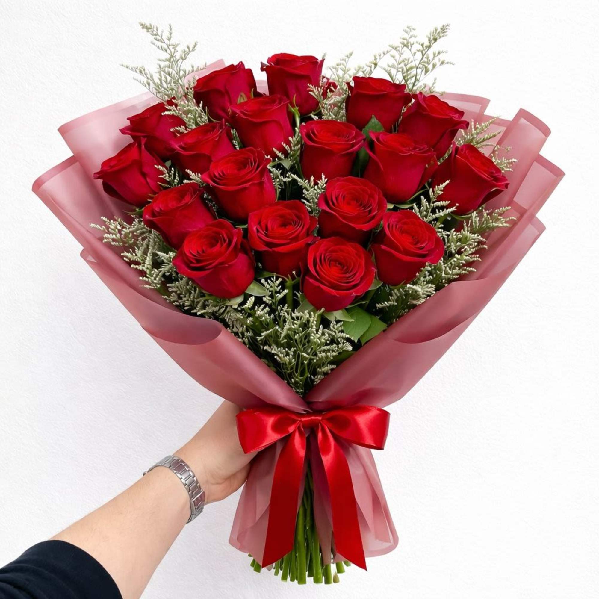Bouquet of red roses wrapped in pink paper with a red ribbon