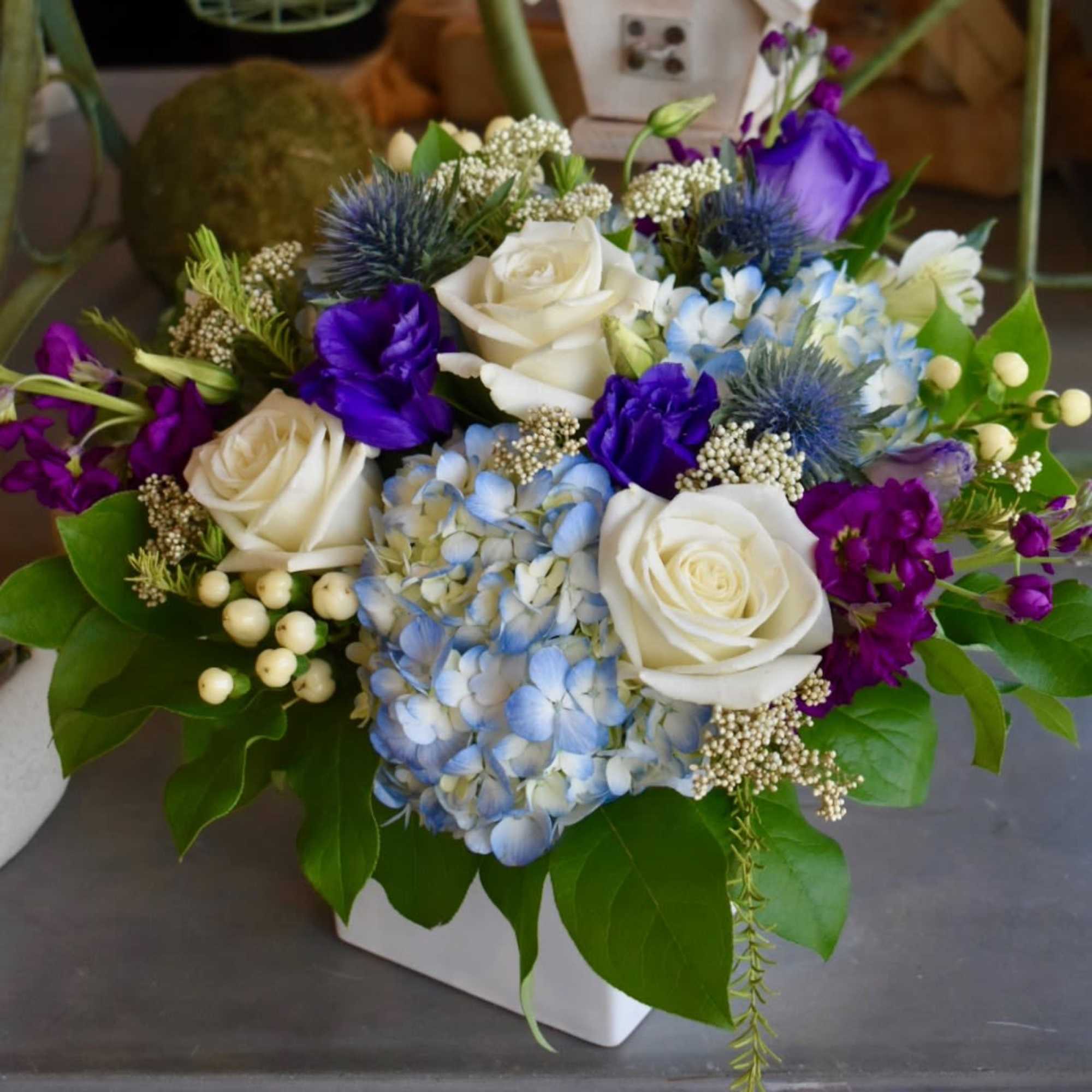 This perfect blend of coastal hues boasts blue hydrangea, white roses, purple