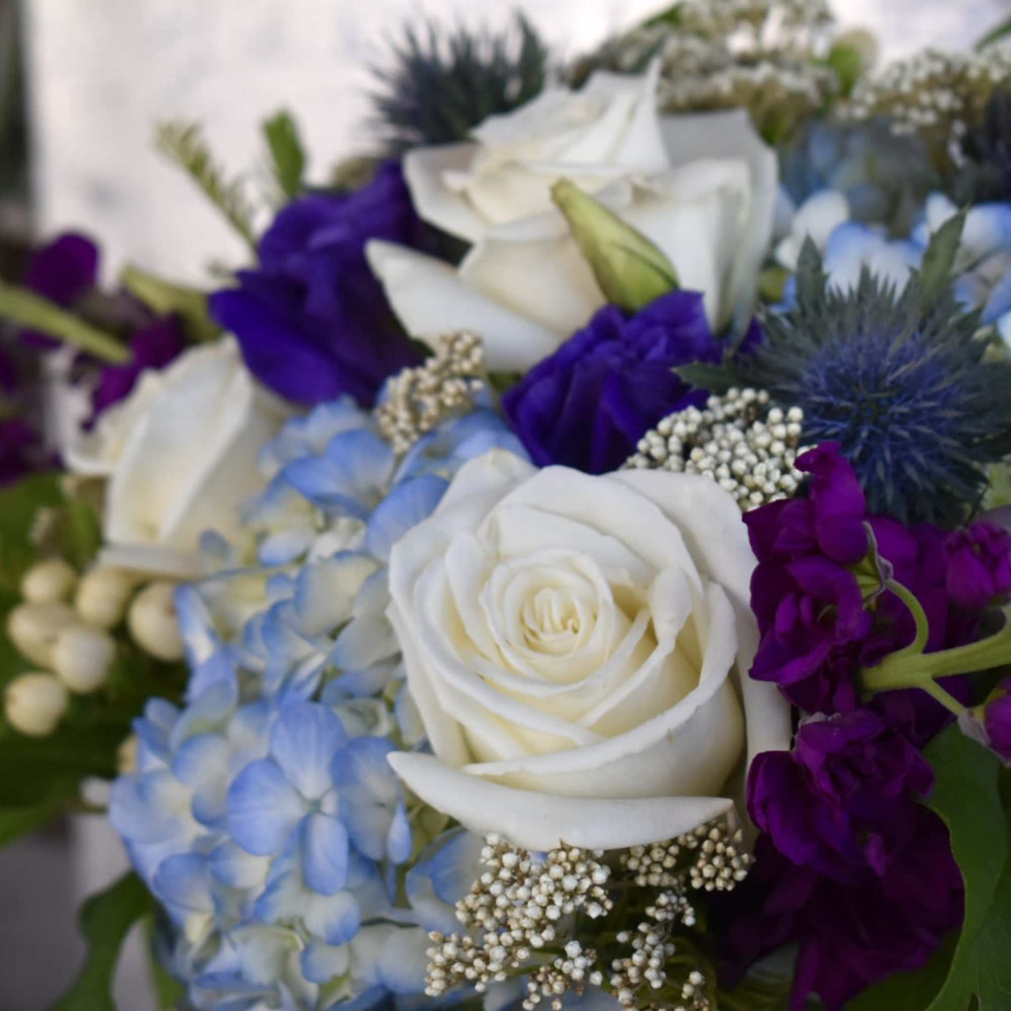 This perfect blend of coastal hues boasts blue hydrangea, white roses, purple