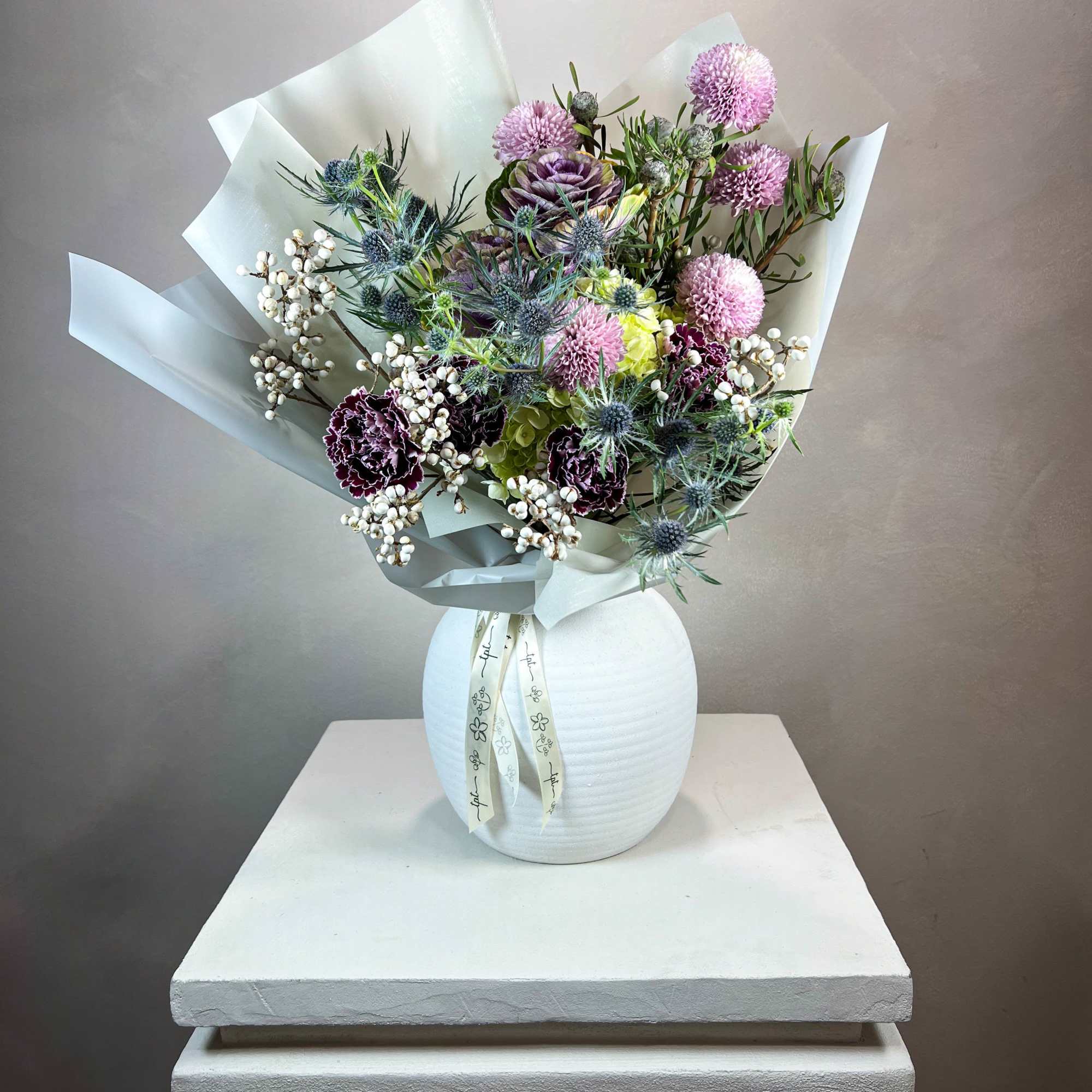 Mixed bouquet in a white vase with pink and purple blooms