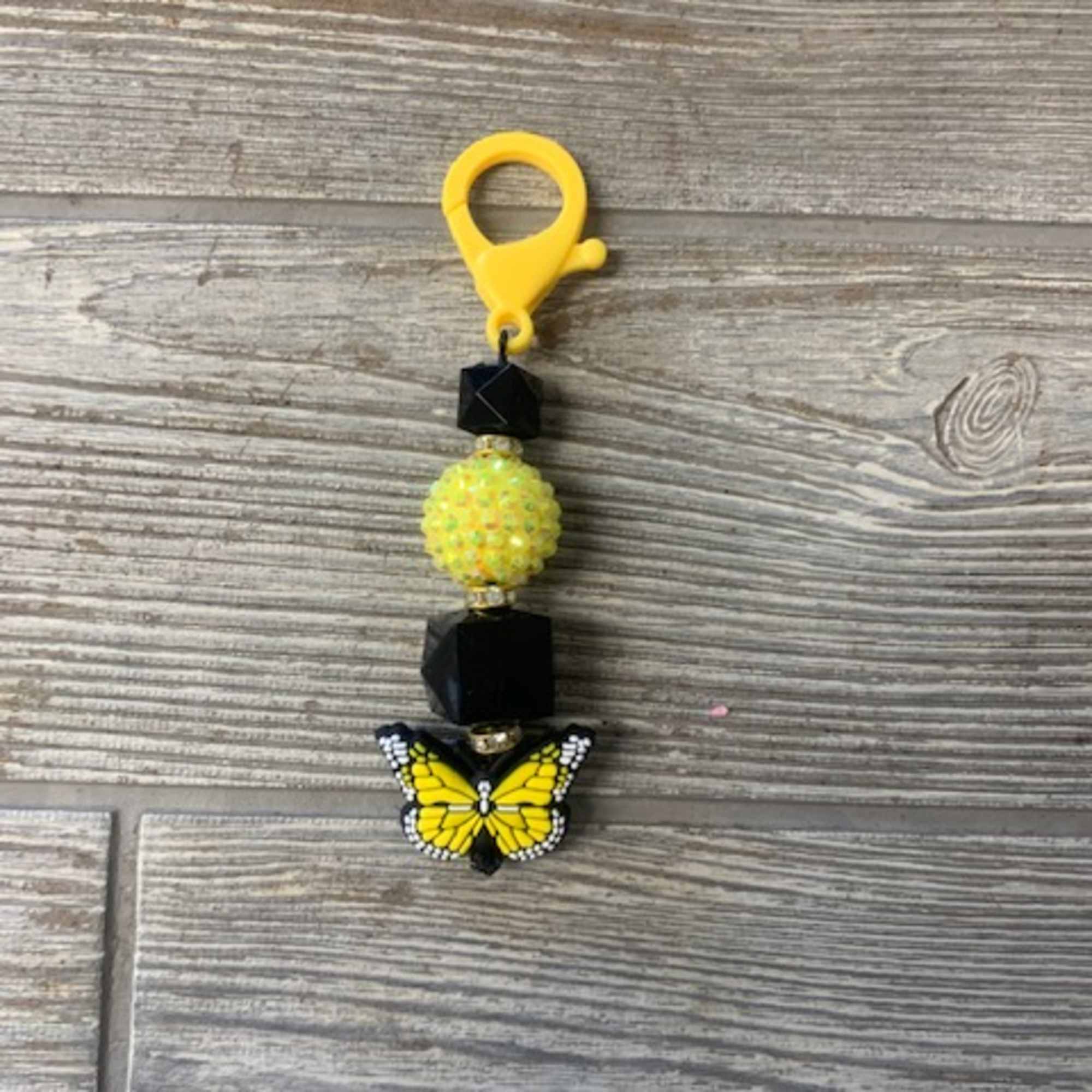 Yellow butterfly beaded charm with black beads and a clip