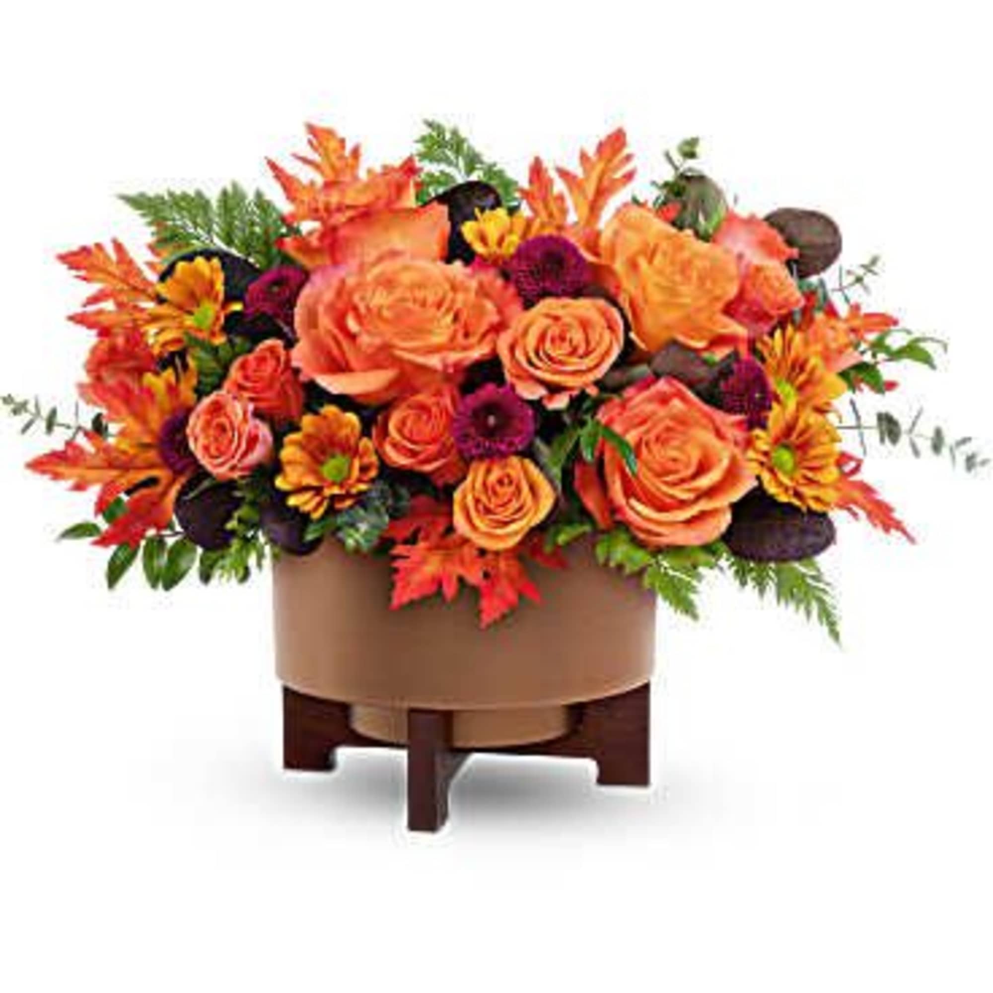 Orange and purple floral arrangement in a round container on a stand