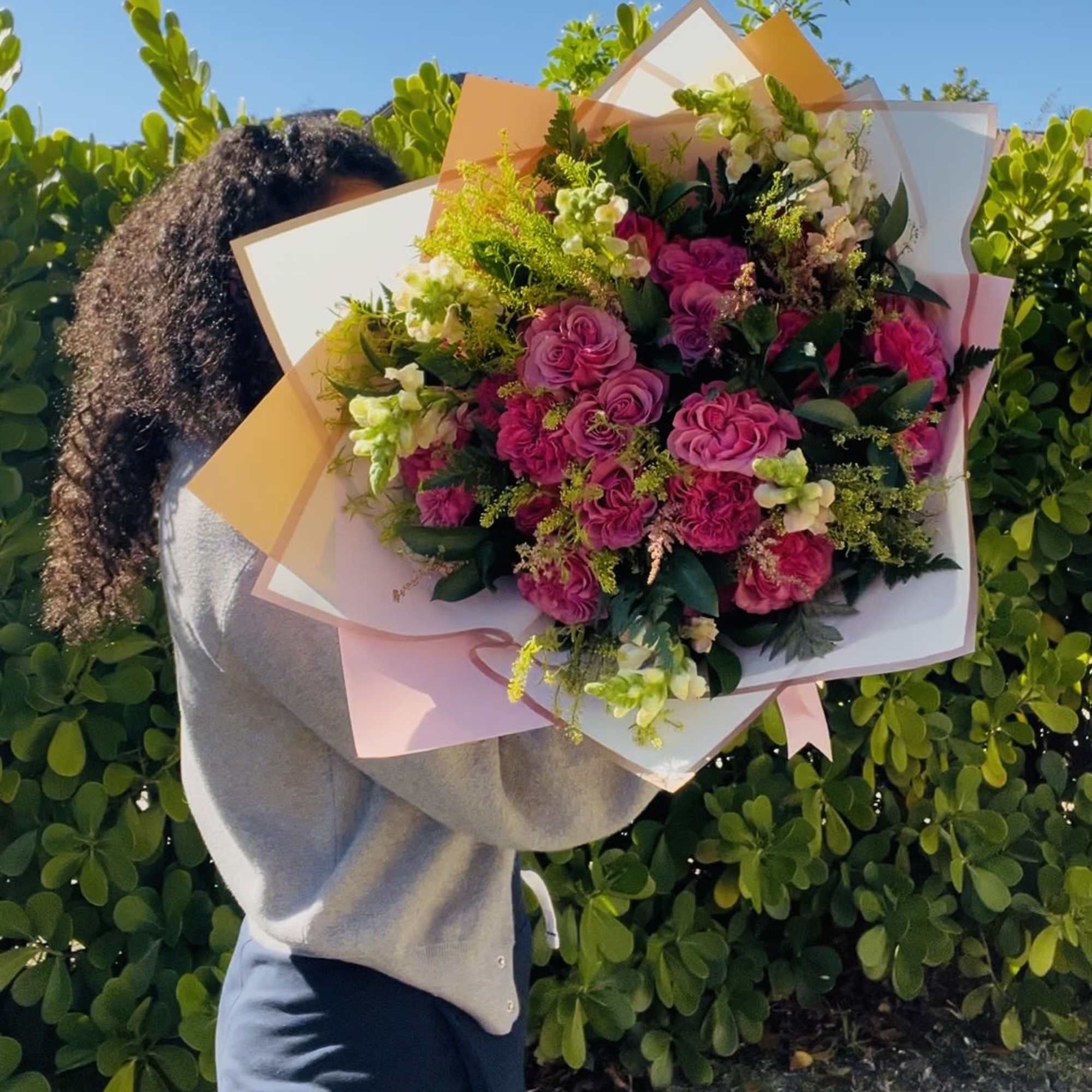 Large bouquet of pink roses with white accents and pastel wrapping