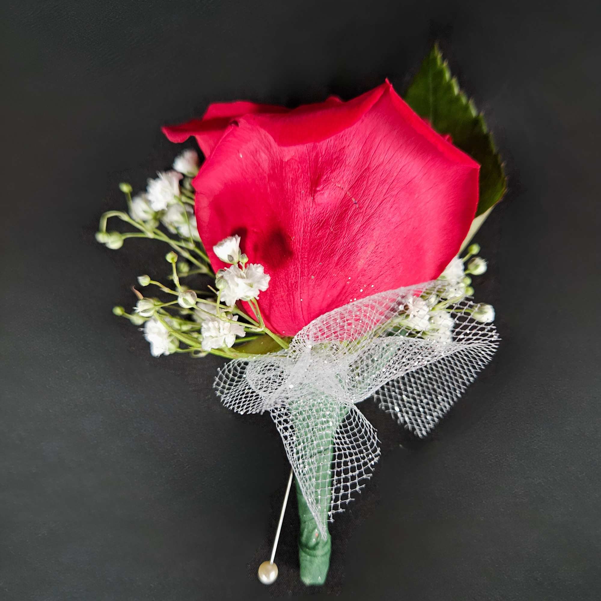 Single red rose boutonniere with white baby's breath and mesh ribbon