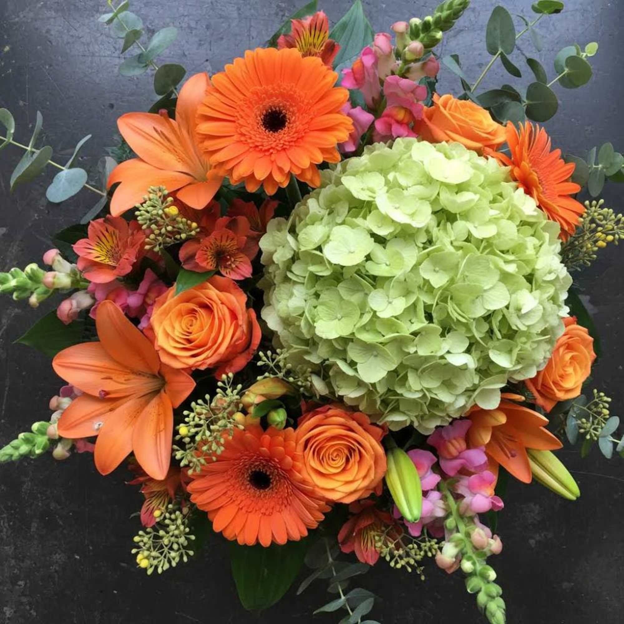 A pale green hydrangea anchors this vibrant everyday bouquet, its cool, cloud-like