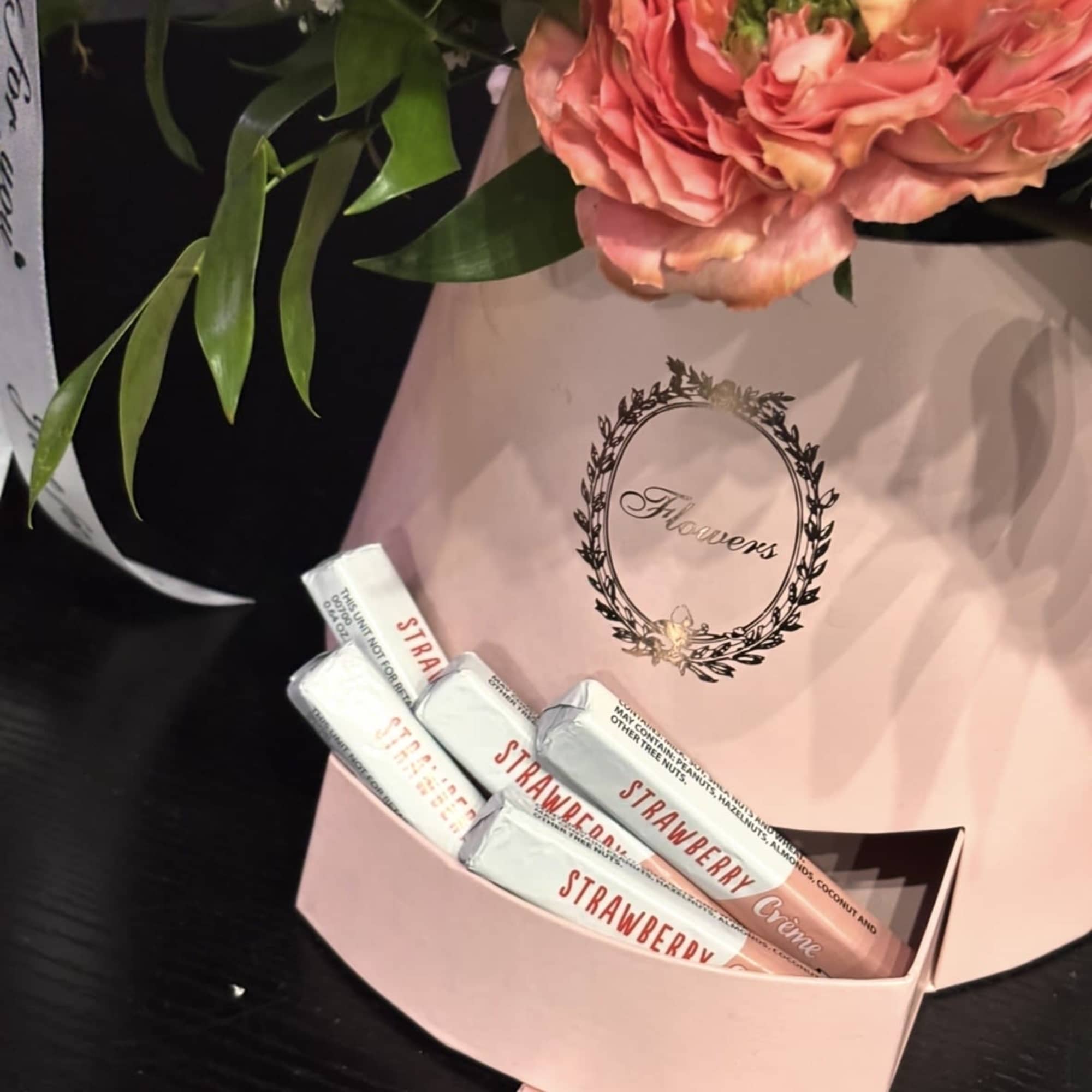 A delicate flower arrangement in a hat box with a pull-out drawer