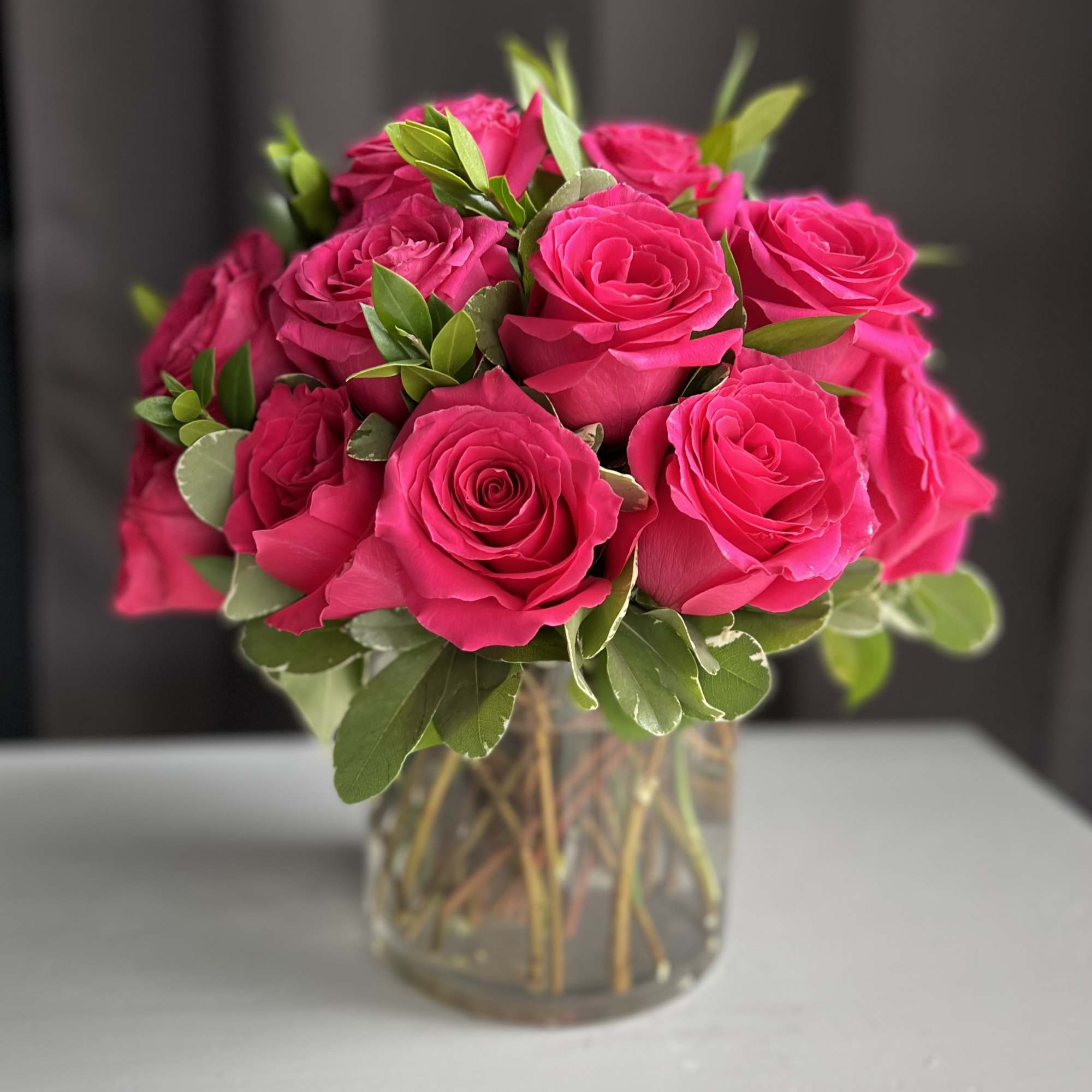 12 premium hot pink roses in a low and lush style

