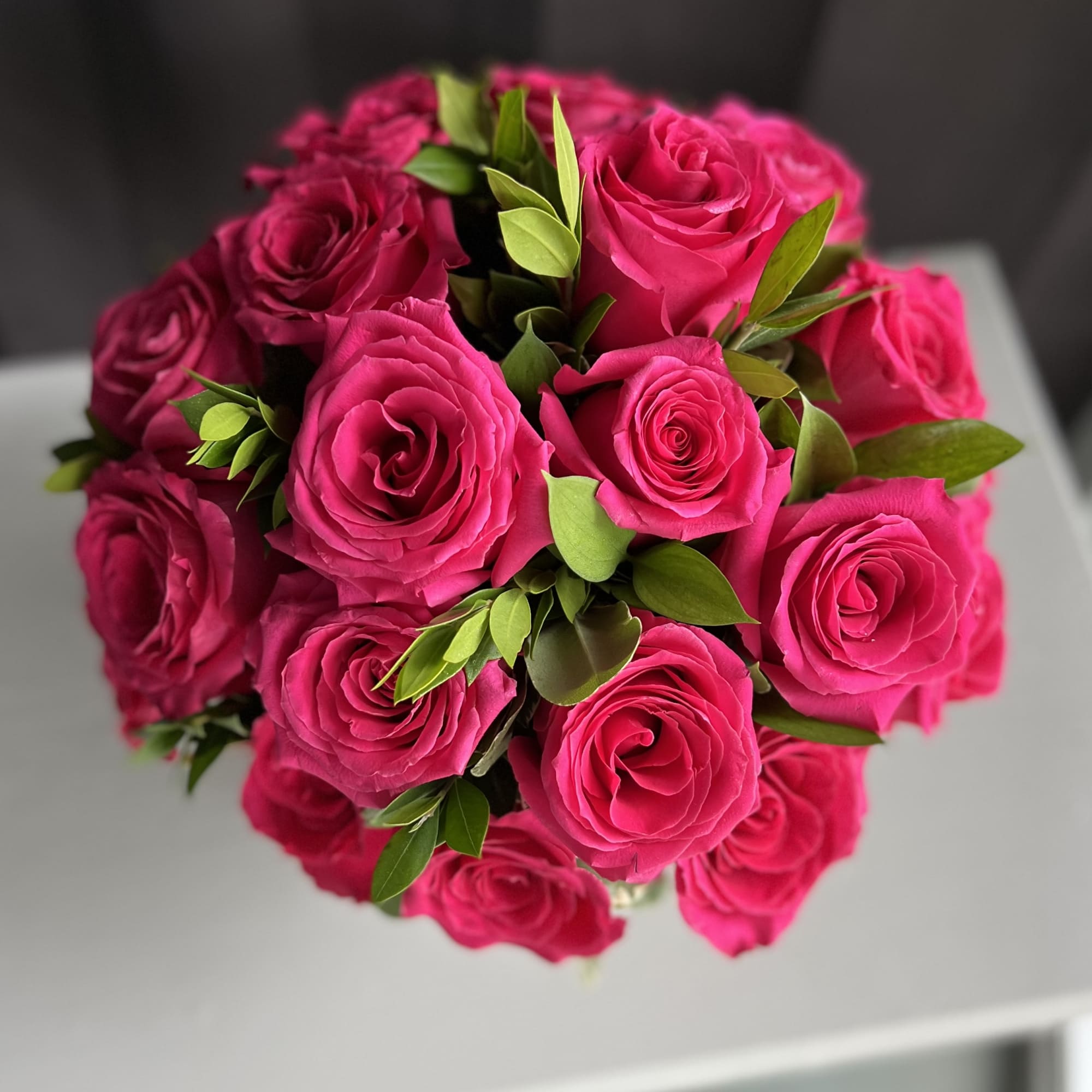 12 premium hot pink roses in a low and lush style

