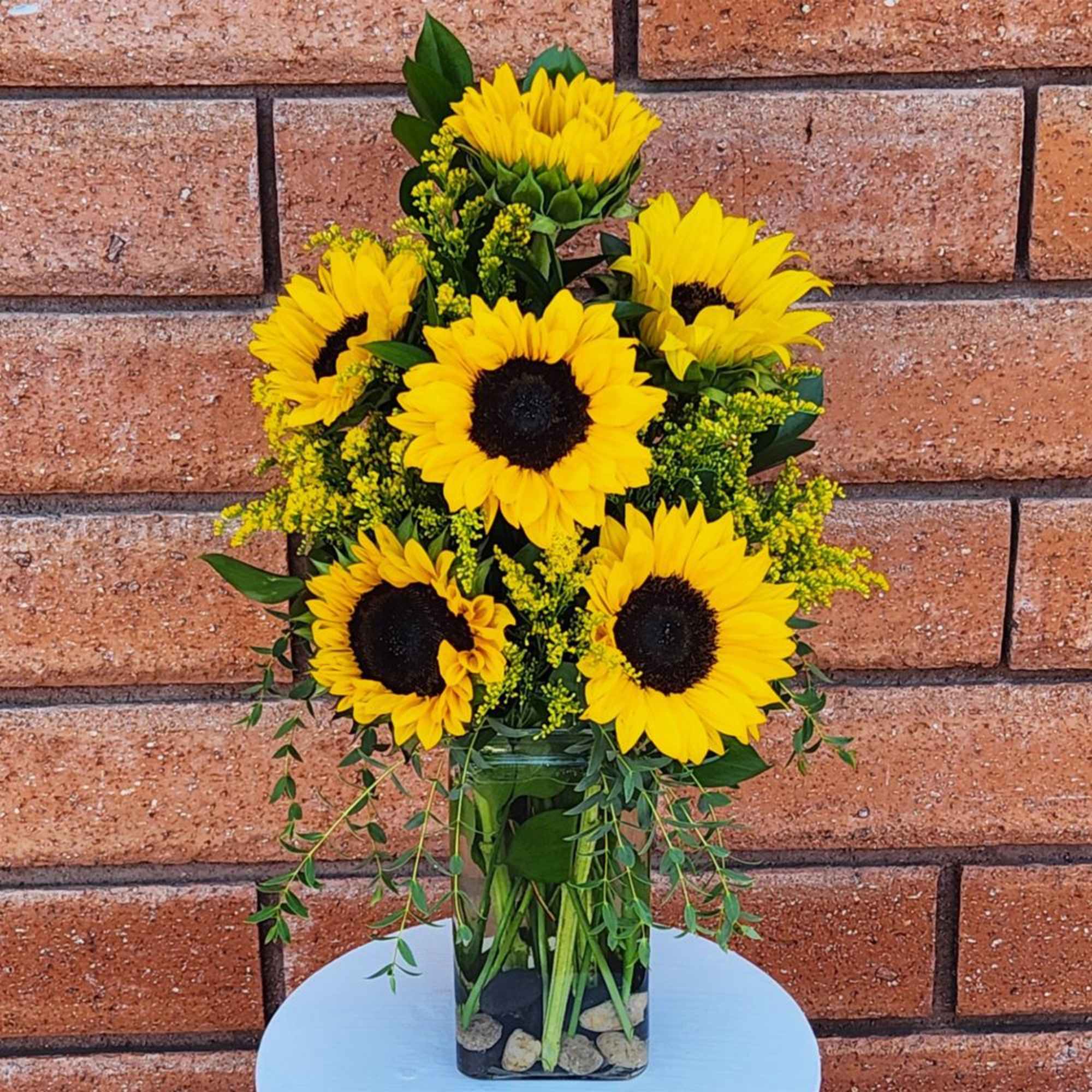 Bouquet of yellow sunflowers in a clear glass vase