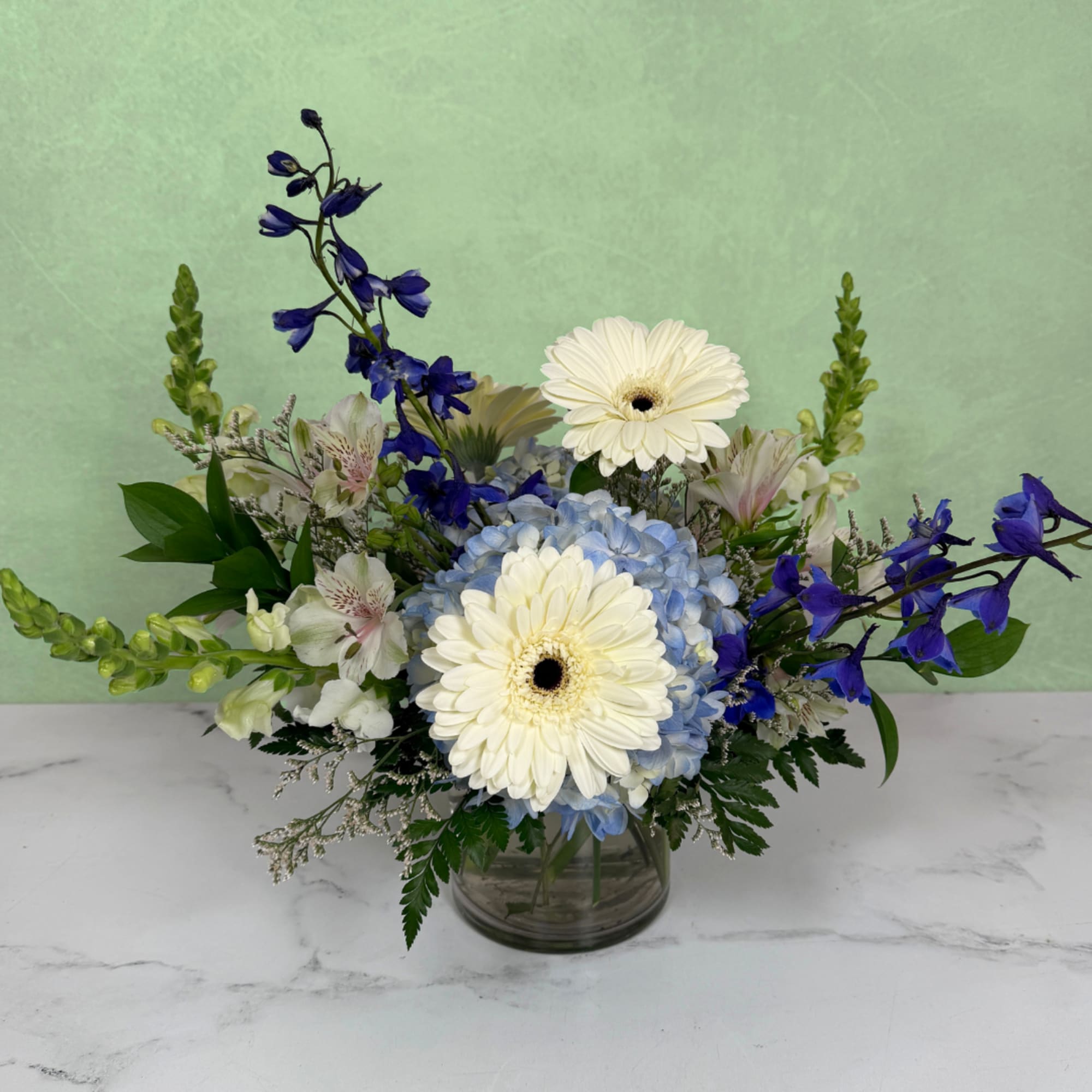 Blue and white flower arrangement in a glass vase