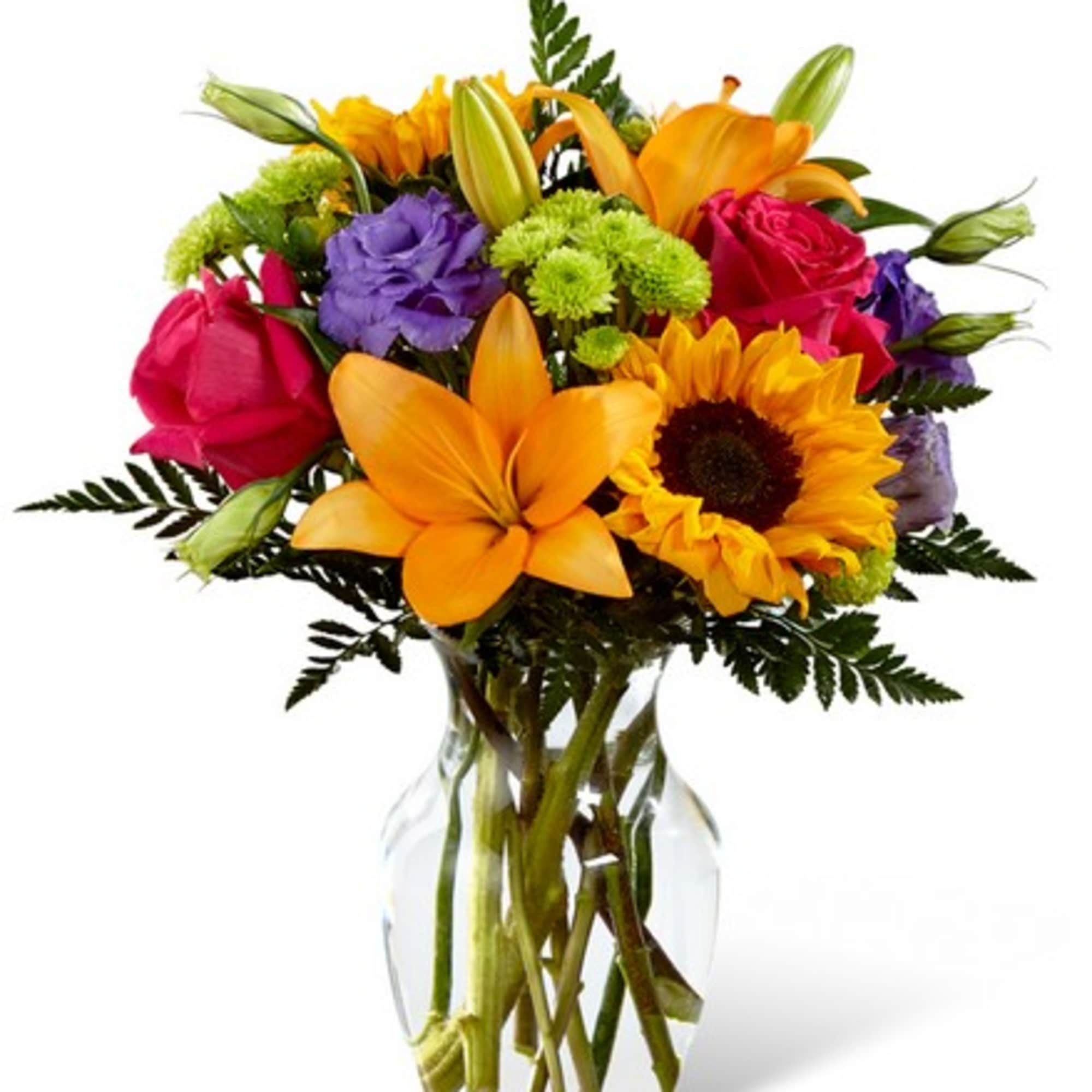 Bright mixed bouquet of lilies, roses, sunflowers, and purple blooms in a glass vase