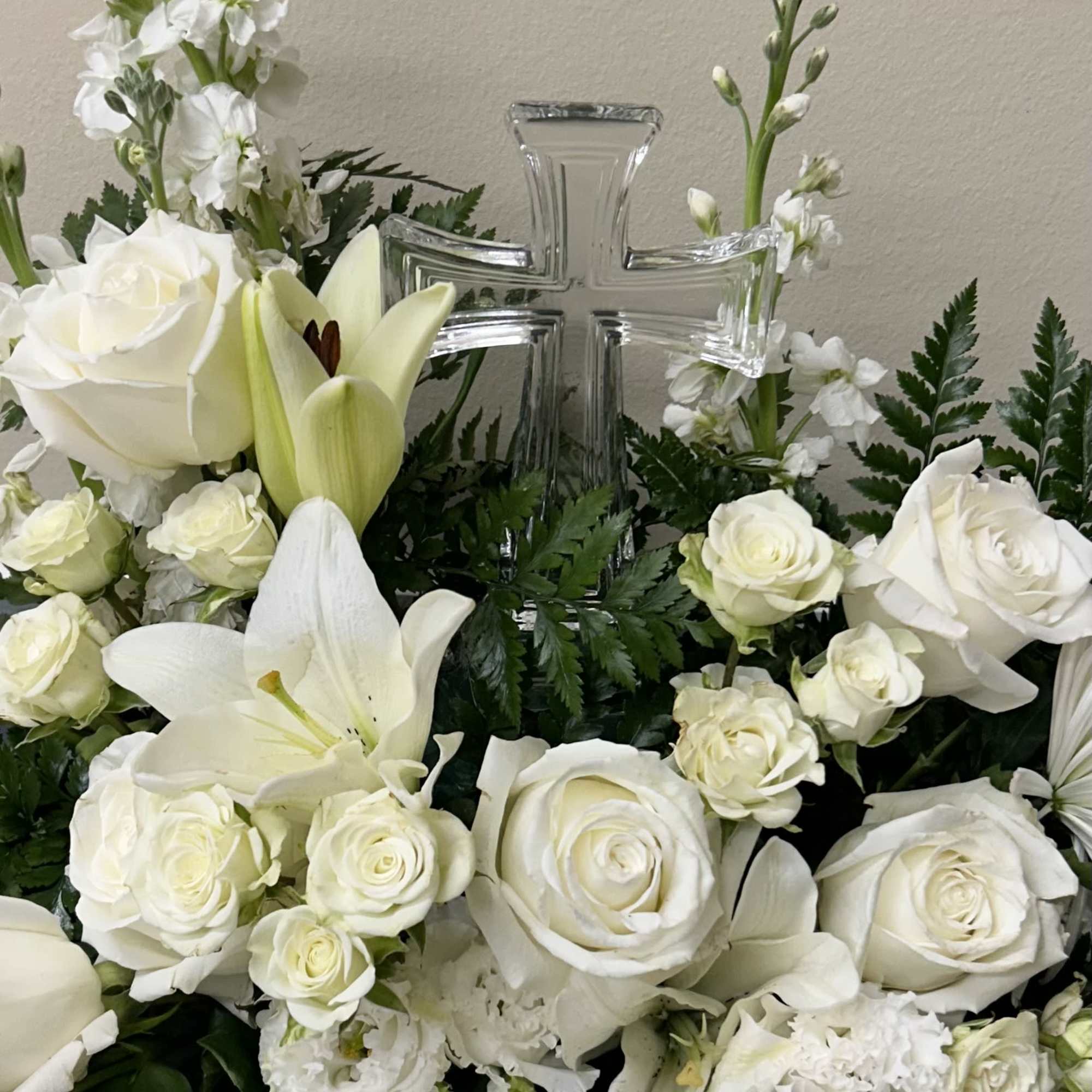 This glass cross is adorned in between the flowers