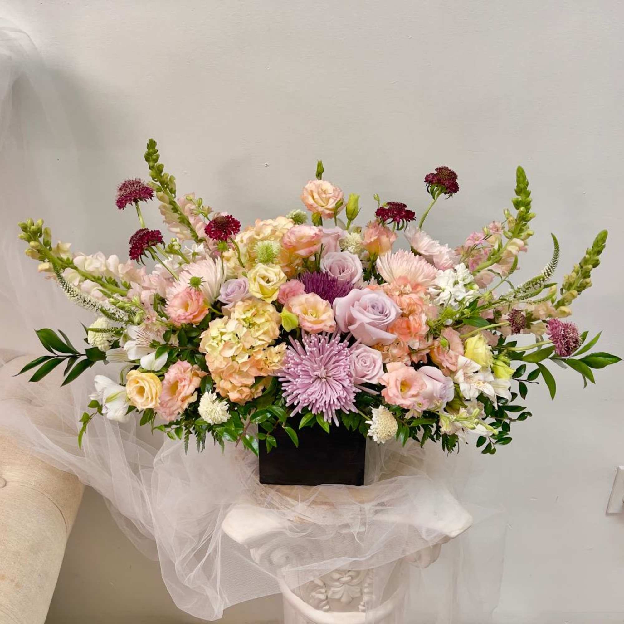 Large pastel floral arrangement in a black rectangular container