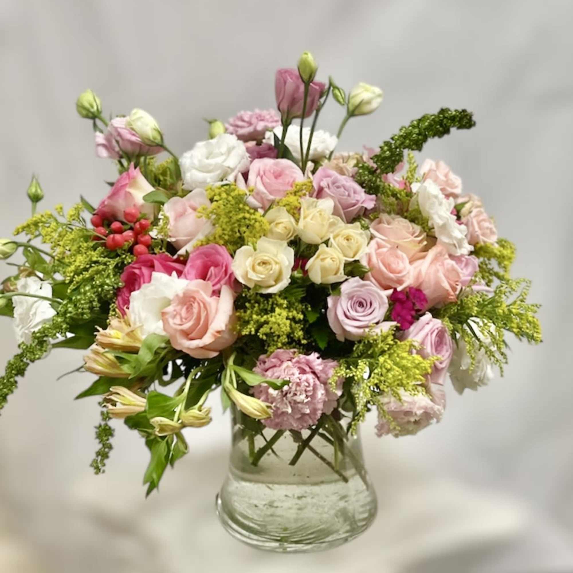 Mixed pink and white roses in a clear glass vase